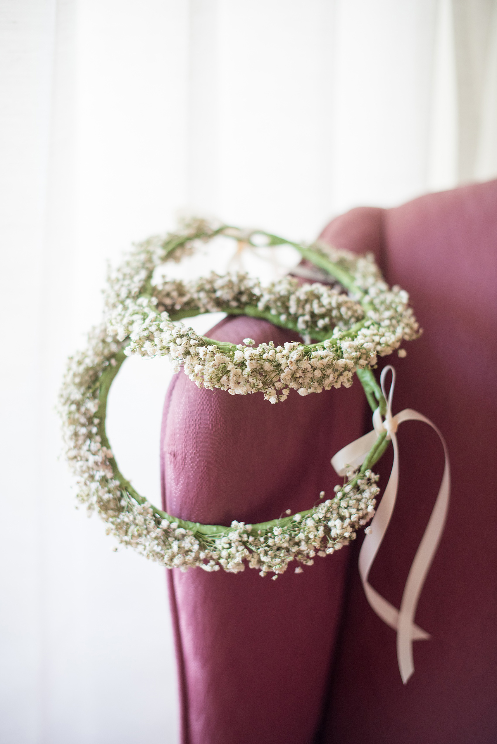 A fall wedding with burgundy, dusty rose and grey details. Two flower crowns with babys breath were prepared for the bride's two flower girls. Mikkel Paige Photography, photographer in Greenville NC and Raleigh captured this wedding at Rock Springs Center, planned by @vivalevent. Click through for more details and pictures from this autumn celebration! #mikkelpaige #northcarolinawedding #southernwedding #flowergirls #flowercrowns #babysbreath