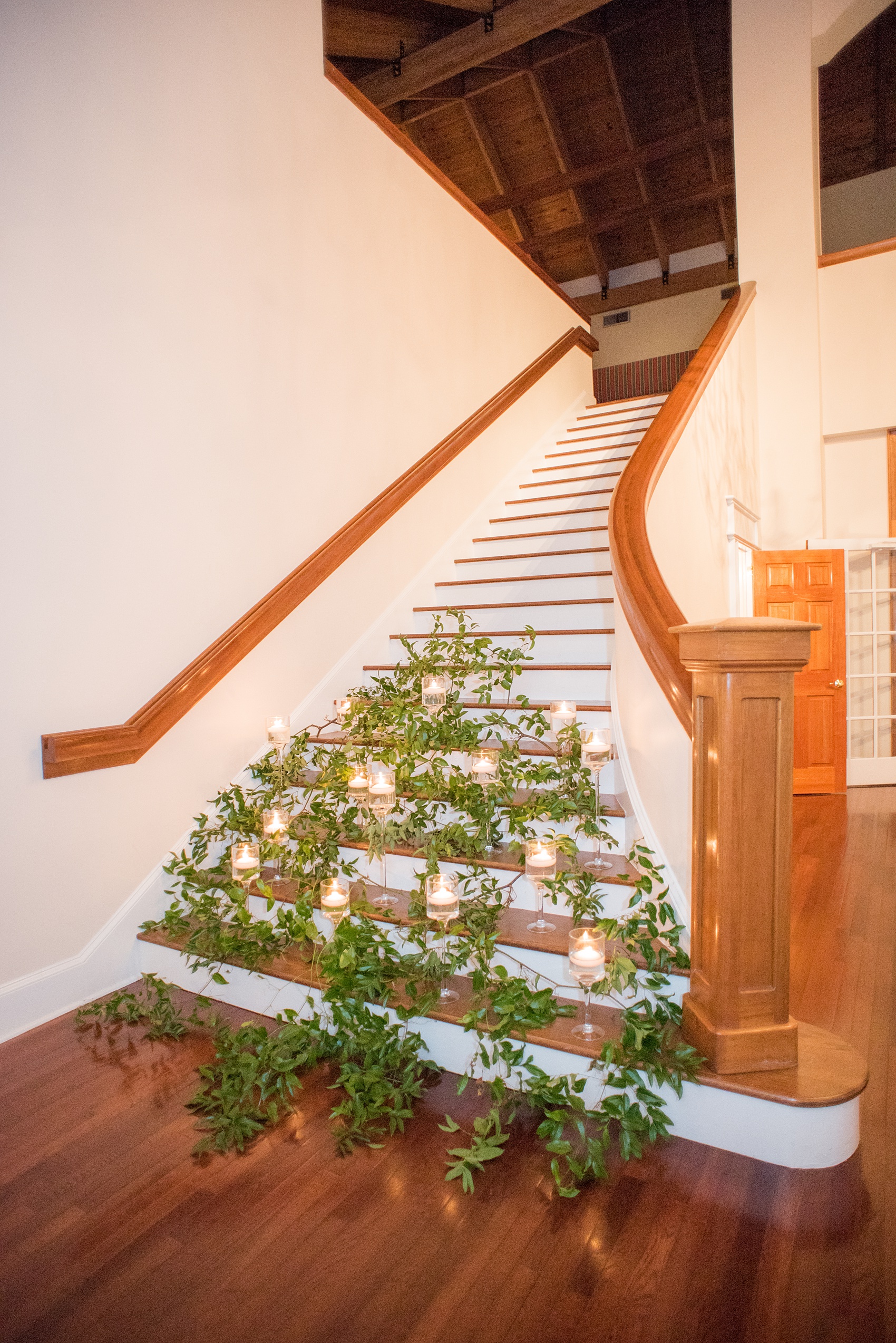 A fall wedding with burgundy, dusty rose and grey details. Candles and greenery lined the two staircases framing the reception room French doors when you walked into the venue. Mikkel Paige Photography, photographer in Greenville NC and Raleigh, captured this wedding at Rock Springs Center, planned by @vivalevent. Click through for more details and pictures from their day! #mikkelpaige #northcarolinawedding #southernwedding #weddingreception #burgundywedding #candlelight #prettystairs