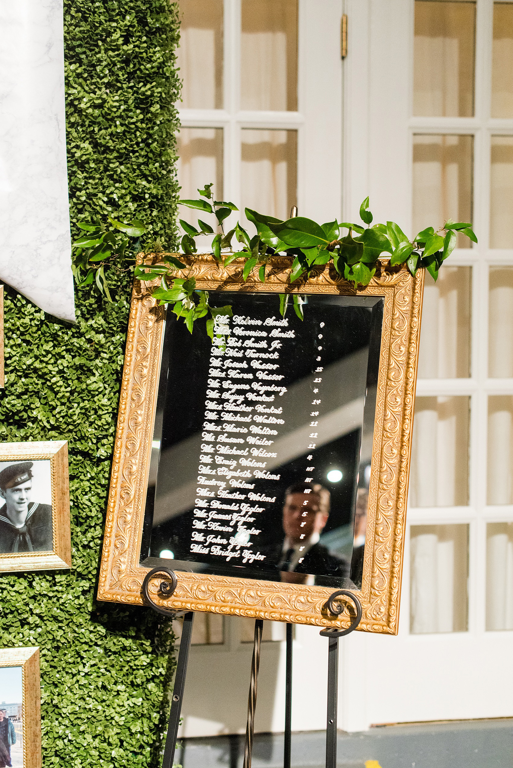 A fall wedding with burgundy, dusty rose and grey details. The bride and groom had a boxwood wall of greenery, that had mirrored signs with guest seats in lieu of escort cards. Mikkel Paige Photography, photographer in Greenville NC and Raleigh captured this wedding at Rock Springs Center, planned by @vivalevent. Click through for more details and pictures from their day! #mikkelpaige #northcarolinawedding #southernwedding #weddingreception #burgundywedding #escortcards #custommirror #customsign