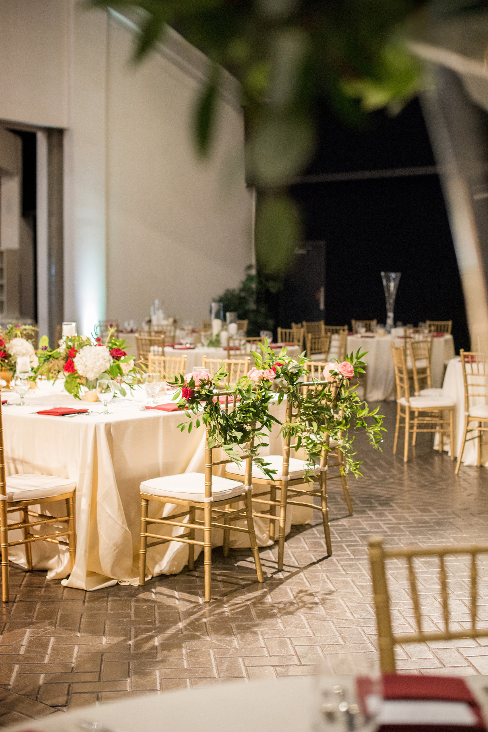 A fall wedding with burgundy, dusty rose and grey details. The reception room was filled with high + low floral centerpieces, with red and pink details, + lots of candlelight. Marble tiles served as table numbers. Mikkel Paige Photography, photographer in Greenville NC and Raleigh, captured this wedding at Rock Springs Center, planned by @vivalevent. Click through for more details and pictures from their day! #mikkelpaige #northcarolinawedding #southernwedding #weddingreception #burgundywedding