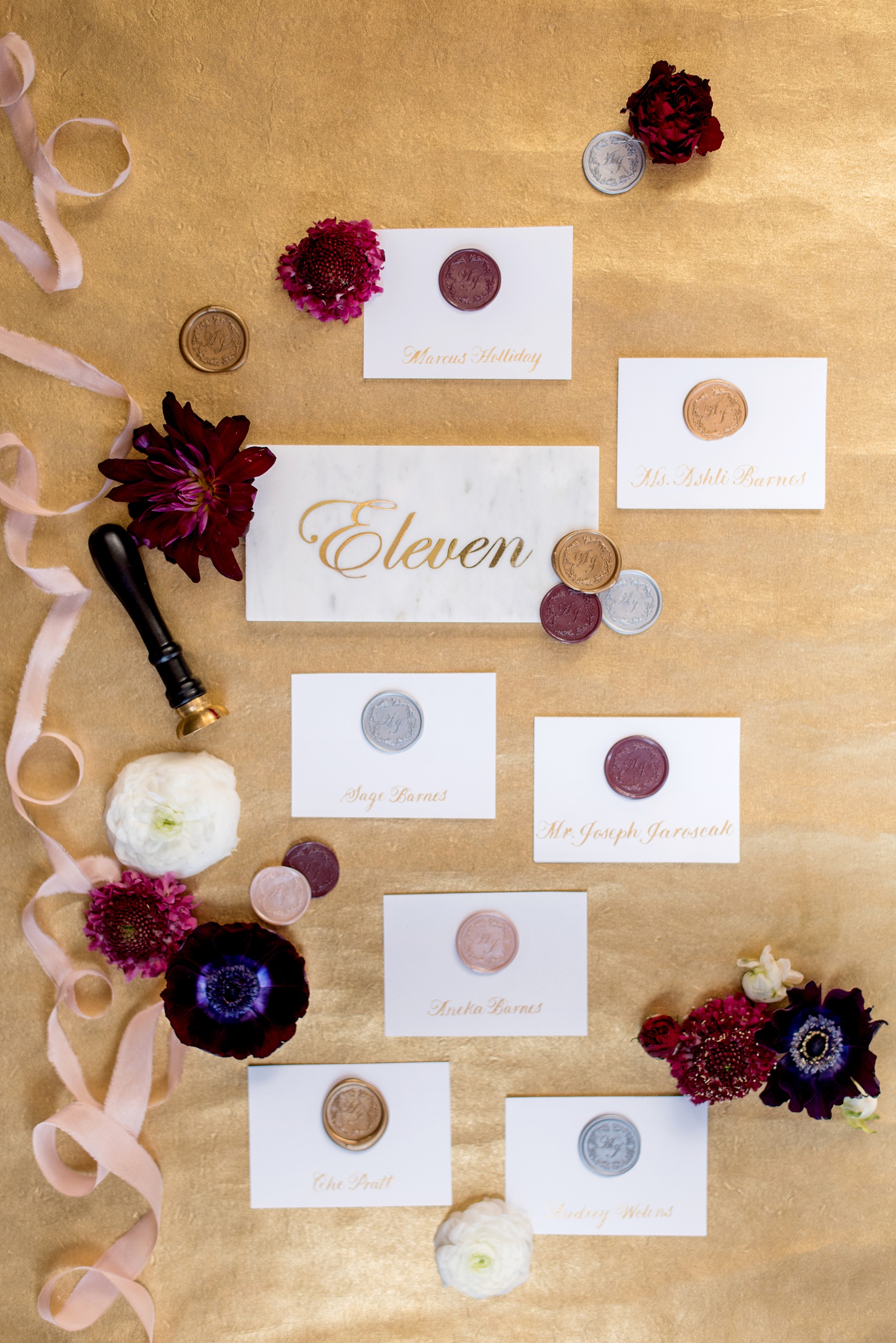 A fall wedding with burgundy, dusty rose and grey details. Mikkel Paige Photography, photographer in Greenville NC and Raleigh, captured this wedding at Rock Springs Center, planned by @vivalevent. The couple's escort cards had names in gold calligraphy with the couple's custom wax seal. Marble tiles showed gold table numbers in script. Click through for details! #mikkelpaige NCwedding #northcarolinawedding #southernwedding #letterpress #weddinginvitation #stationery #waxseal #tablenumbers