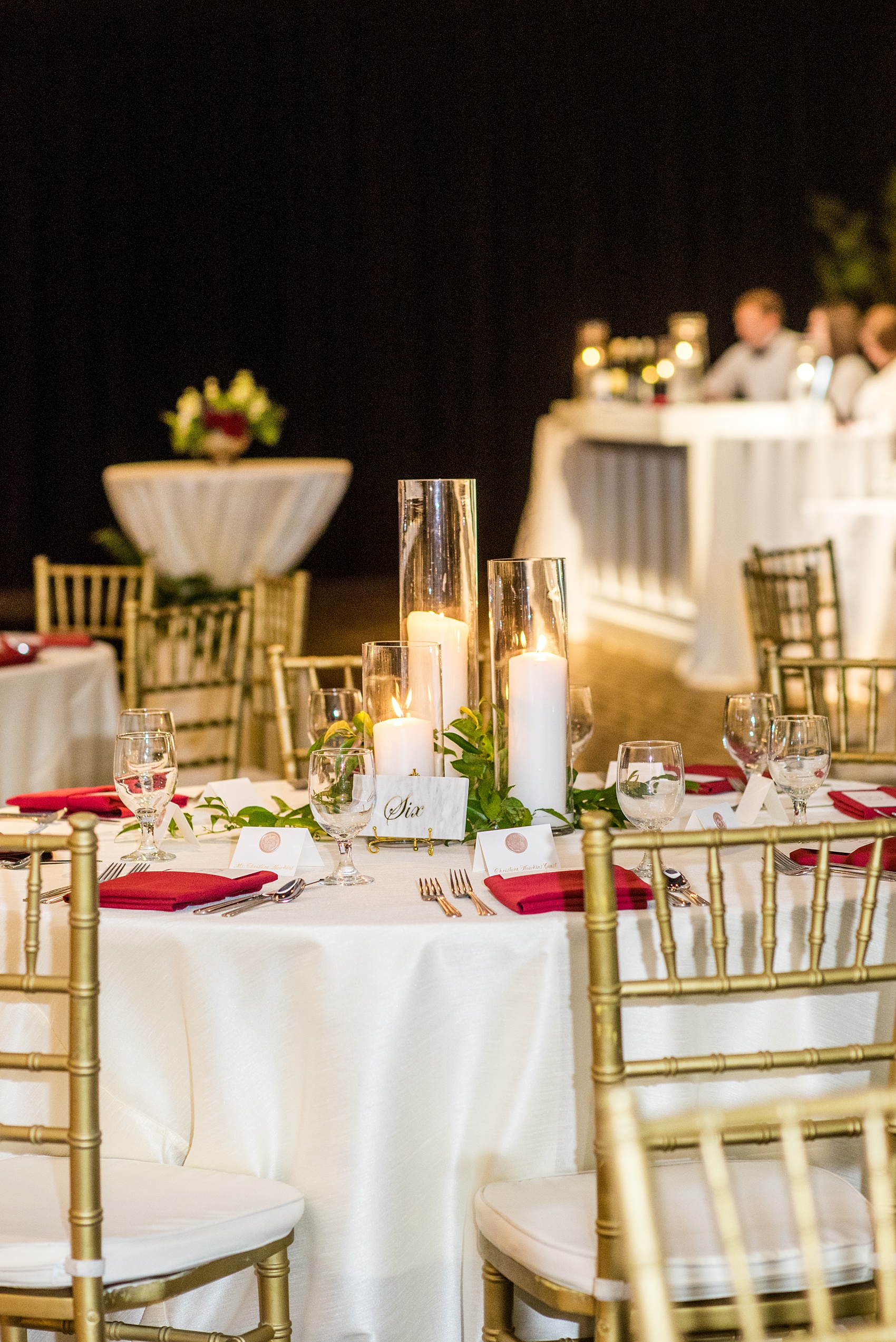 A fall wedding with burgundy, dusty rose and grey details. The reception room was filled with high + low floral centerpieces, with red and pink details, + lots of candlelight. Marble tiles served as table numbers. Mikkel Paige Photography, photographer in Greenville NC and Raleigh, captured this wedding at Rock Springs Center, planned by @vivalevent. Click through for more details and pictures from their day! #mikkelpaige #northcarolinawedding #southernwedding #weddingreception #burgundywedding