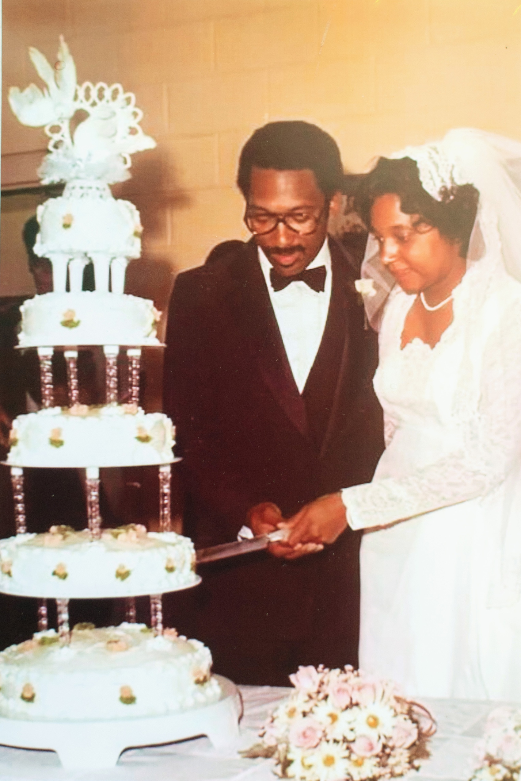 A fall wedding with burgundy, dusty rose and grey details. The couple cut their three tiered cake, reminiscent of the bride's parents' wedding day, shown in this vintage photo. Mikkel Paige Photography, photographer in Greenville NC and Raleigh, captured this wedding at Rock Springs Center, planned by @vivalevent. Click through for more details and pictures from their day! #mikkelpaige NCwedding #northcarolinawedding #southernwedding #vintageweddingphotos #burgundywedding