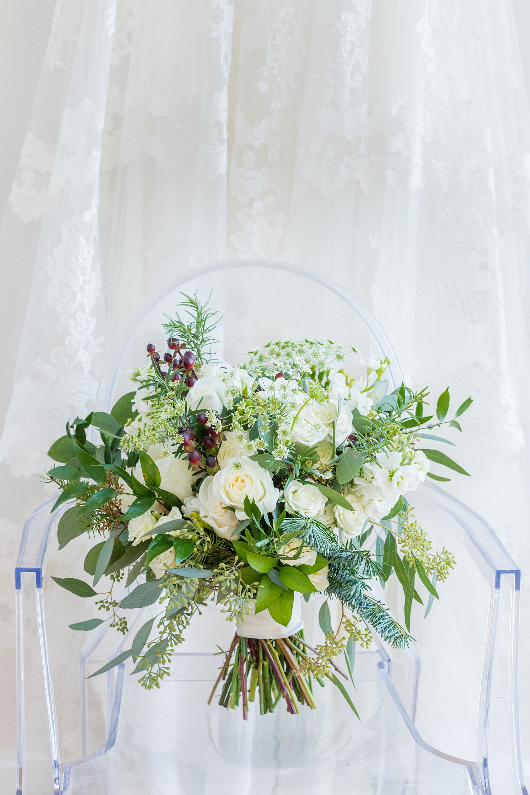 Pictures from a Christmas inspired wedding in downtown Raleigh, North Carolina by Mikkel Paige Photography. The bride carried a holiday bouquet for her church ceremony at The Stockroom at 230 with rosemary, ranunculus and berries. Click through for more ideas from their beautiful celebration, including decor photos in a green and gold decor palette for their reception. #mikkelpaige #raleighweddingphotographer #downtownRaleigh #greenandgoldwedding #gettingready #holidaybouquet #christmaswedding