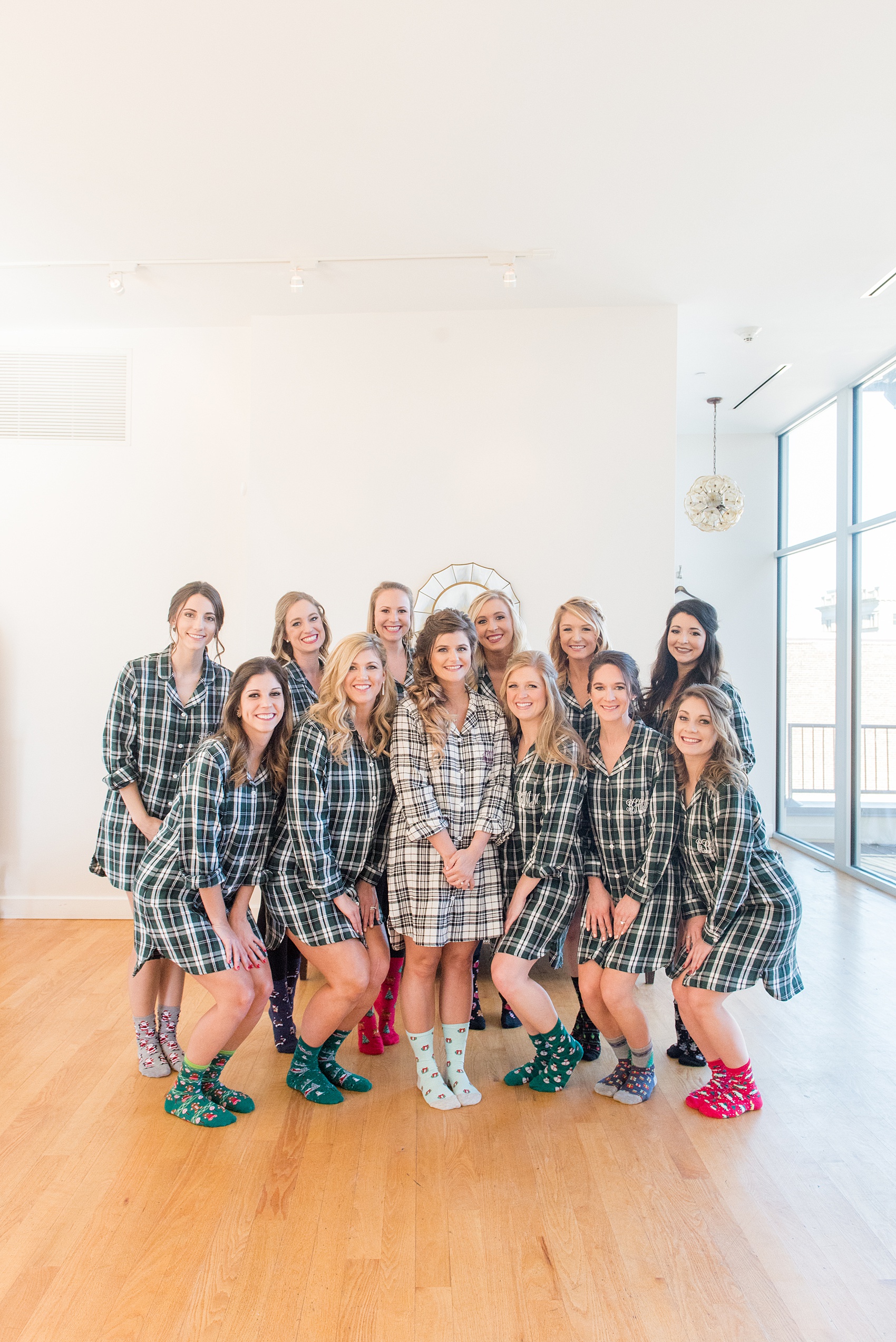 Pictures from a Christmas inspired wedding in downtown Raleigh, North Carolina by Mikkel Paige Photography. The bride and bridesmaids got ready for a church ceremony and reception at The Stockroom at 230, at The Glass Box, wearing plaid pajamas with monograms. Click through for more ideas from a beautiful celebration, including decor photos. #mikkelpaige #raleighweddingphotographer #downtownRaleigh #greenandgoldwedding #gettingready #christmaswedding #plaidpajamas