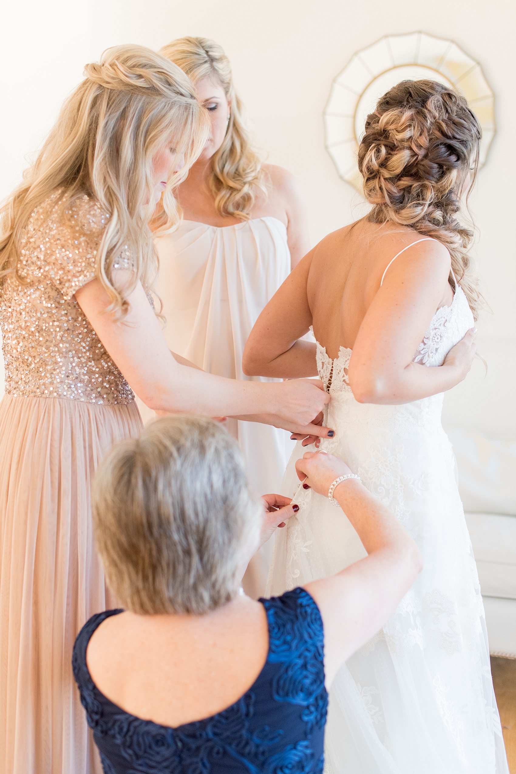 Pictures from a Christmas inspired wedding in downtown Raleigh, North Carolina by Mikkel Paige Photography. The bride and bridesmaids got ready for the church ceremony and reception at The Stockroom at 230, at The Glass Box in mismatched pink dresses. Click through for more ideas from a beautiful celebration, including decor photos in a green and gold decor palette. #mikkelpaige #raleighweddingphotographer #downtownRaleigh #greenandgoldwedding #gettingready #christmaswedding #bridesmaids #bridal