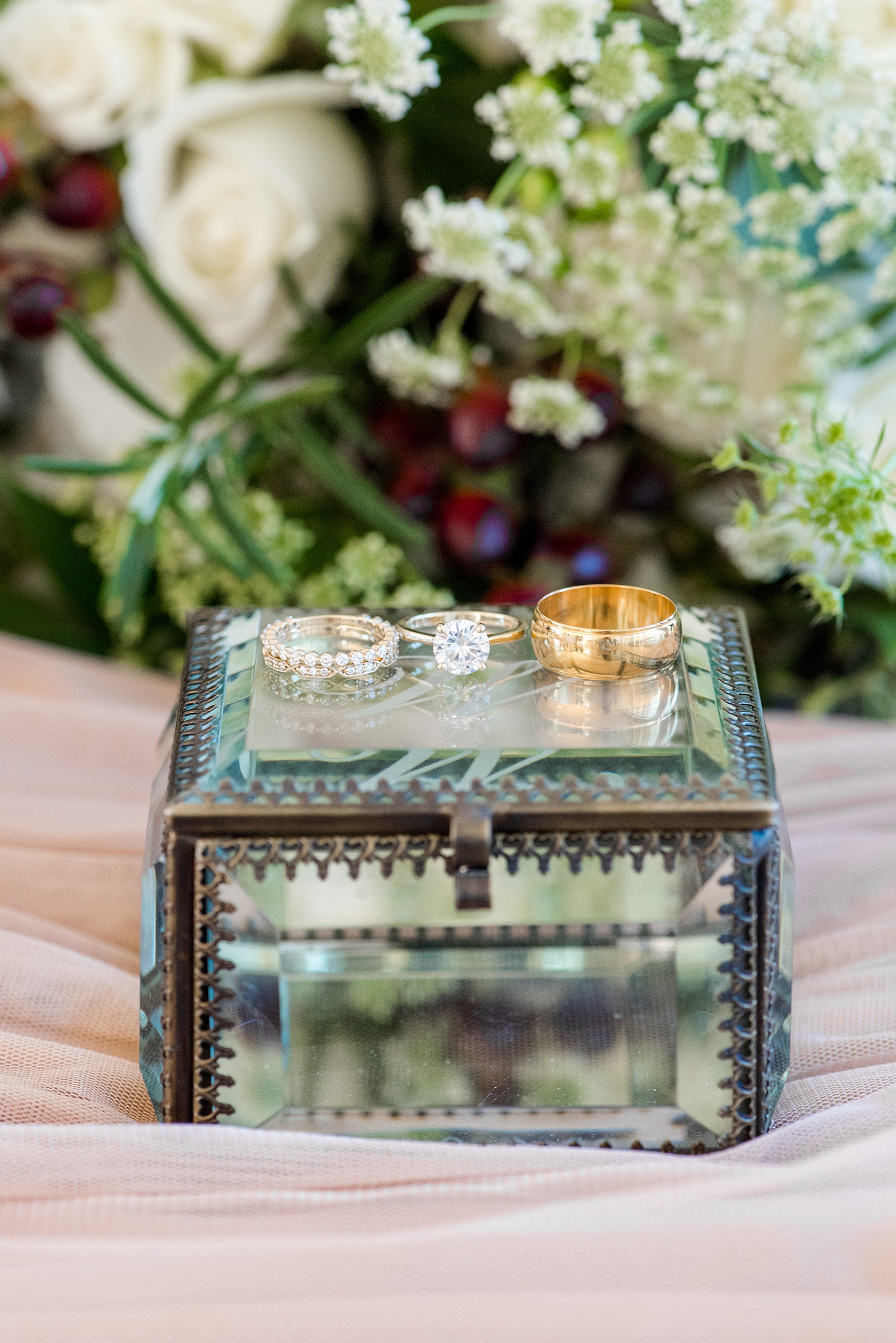 Pictures from a Christmas inspired wedding in downtown Raleigh, North Carolina by Mikkel Paige Photography. The bride got ready for their wedding at The Stockroom at 230 at The Glass Box while their photographer captured their ring detail images. Click through for more ideas from their beautiful celebration, including decor photos in a green and gold decor palette for their reception. #mikkelpaige #raleighweddingphotographer #downtownRaleigh #greenandgoldwedding #gettingready #ringphotos