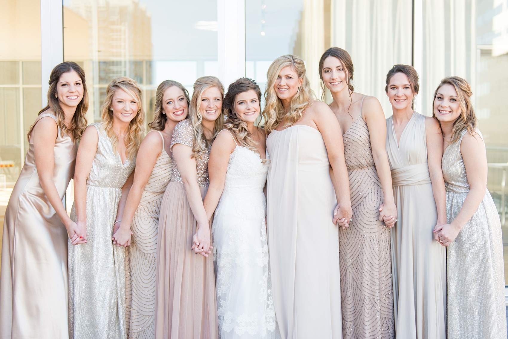 Pictures from a Christmas inspired wedding in downtown Raleigh, North Carolina by Mikkel Paige Photography. The bridesmaids got ready at The Glass Box and wore mismatched pink gowns. Click through for more ideas from a beautiful celebration, including decor photos in a green and gold decor palette for their reception at The Stockroom at 230. #mikkelpaige #raleighweddingphotographer #downtownRaleigh #weddingparty #bridalparty #pinkbridesmaids #sequingowns #winterwedding