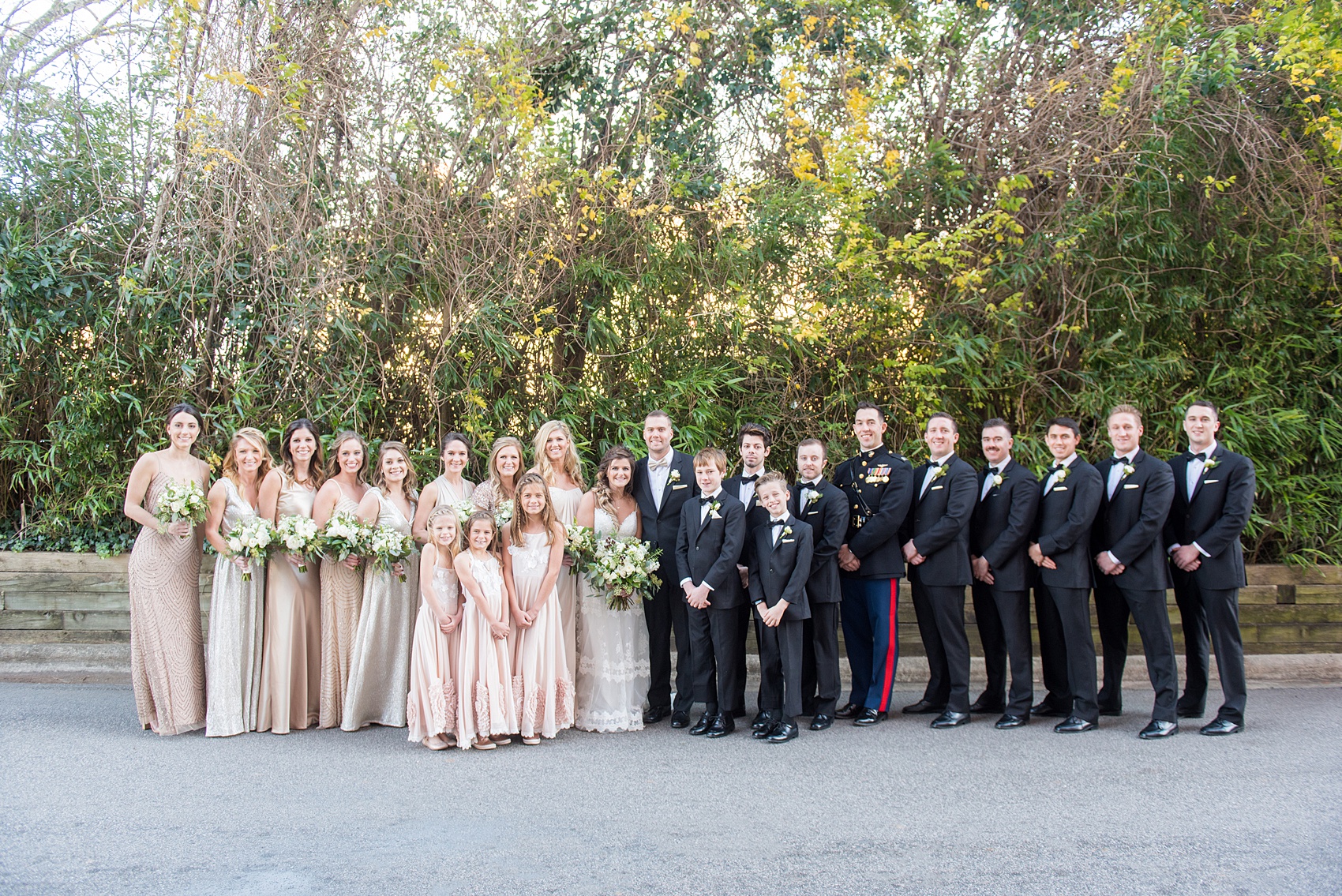 Pictures from a Christmas inspired wedding in downtown Raleigh, North Carolina by Mikkel Paige Photography. The bridesmaidswore mismatched pink gowns and groomsmen tuxedos. Click through for more ideas from a beautiful celebration, including decor photos in a green and gold decor palette for their reception at The Stockroom at 230. #mikkelpaige #raleighweddingphotographer #downtownRaleigh #weddingparty #bridalparty #pinkbridesmaids #sequingowns #winterwedding