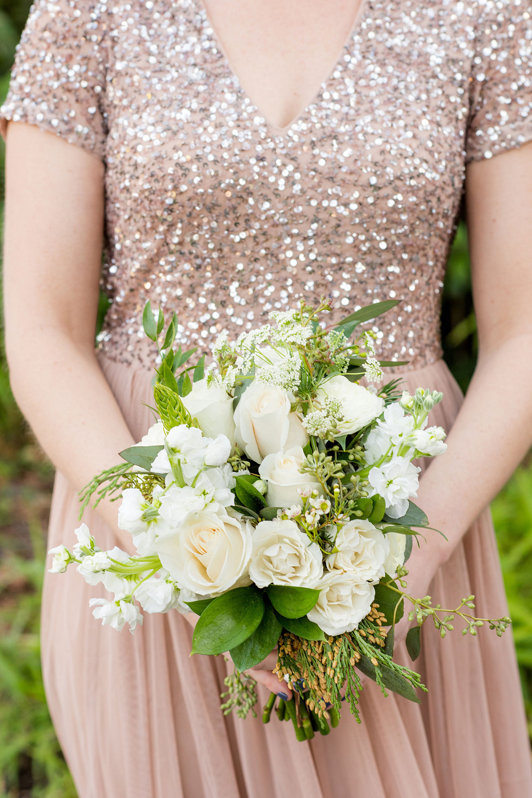 Pictures from a Christmas inspired wedding in downtown Raleigh, North Carolina by Mikkel Paige Photography. The bridesmaids carried white bouquets with eucalyptus and white stock for a church ceremony and reception at The Stockroom at 230. Click through for more ideas from their beautiful celebration, including decor photos in a green and gold decor palette. #mikkelpaige #raleighweddingphotographer #downtownRaleigh #greenandgoldwedding #gettingready #whitebouquet #christmaswedding