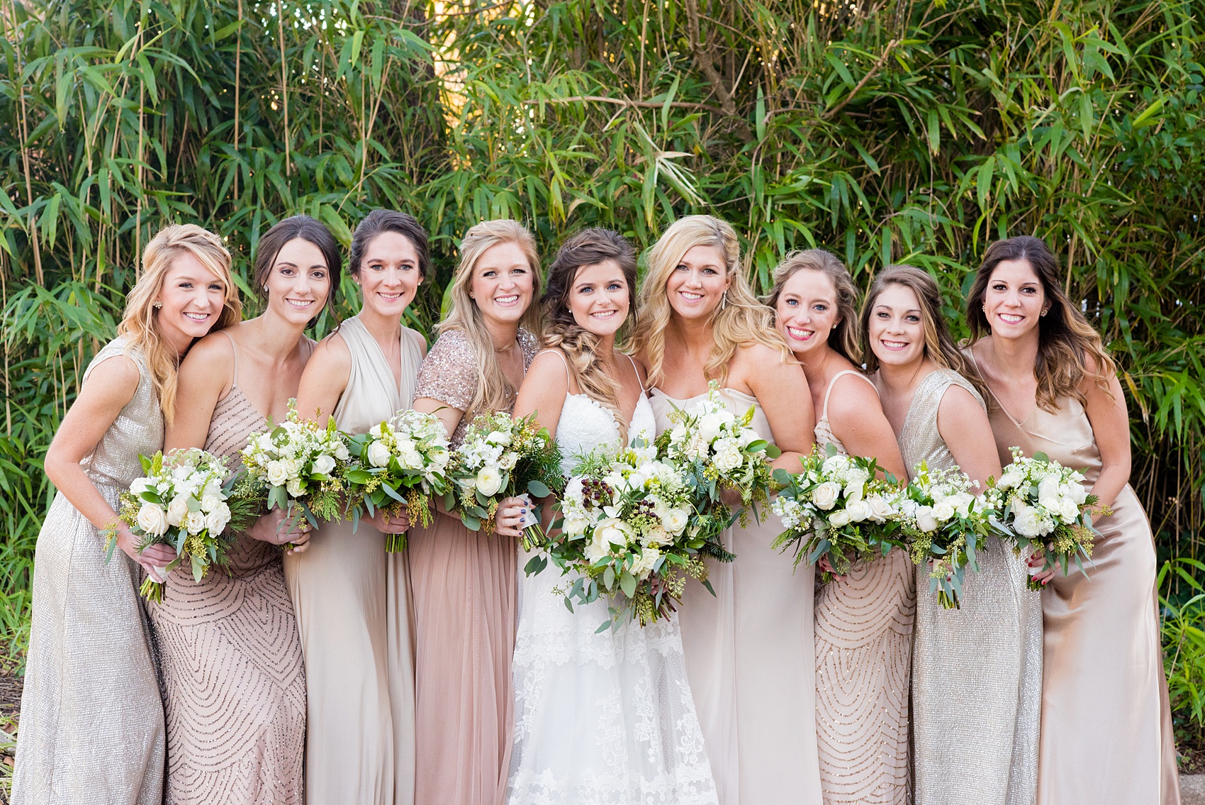 Pictures from a Christmas inspired wedding in downtown Raleigh, North Carolina by Mikkel Paige Photography. The bridesmaids wore mismatched pink gowns and carried white and green, holiday inspired bouquets. Click through for more ideas from a beautiful celebration, including decor photos in a green and gold decor palette for their reception at The Stockroom at 230. #mikkelpaige #raleighweddingphotographer #downtownRaleigh #weddingparty #bridalparty #pinkbridesmaids #winterwedding #whitebouquets