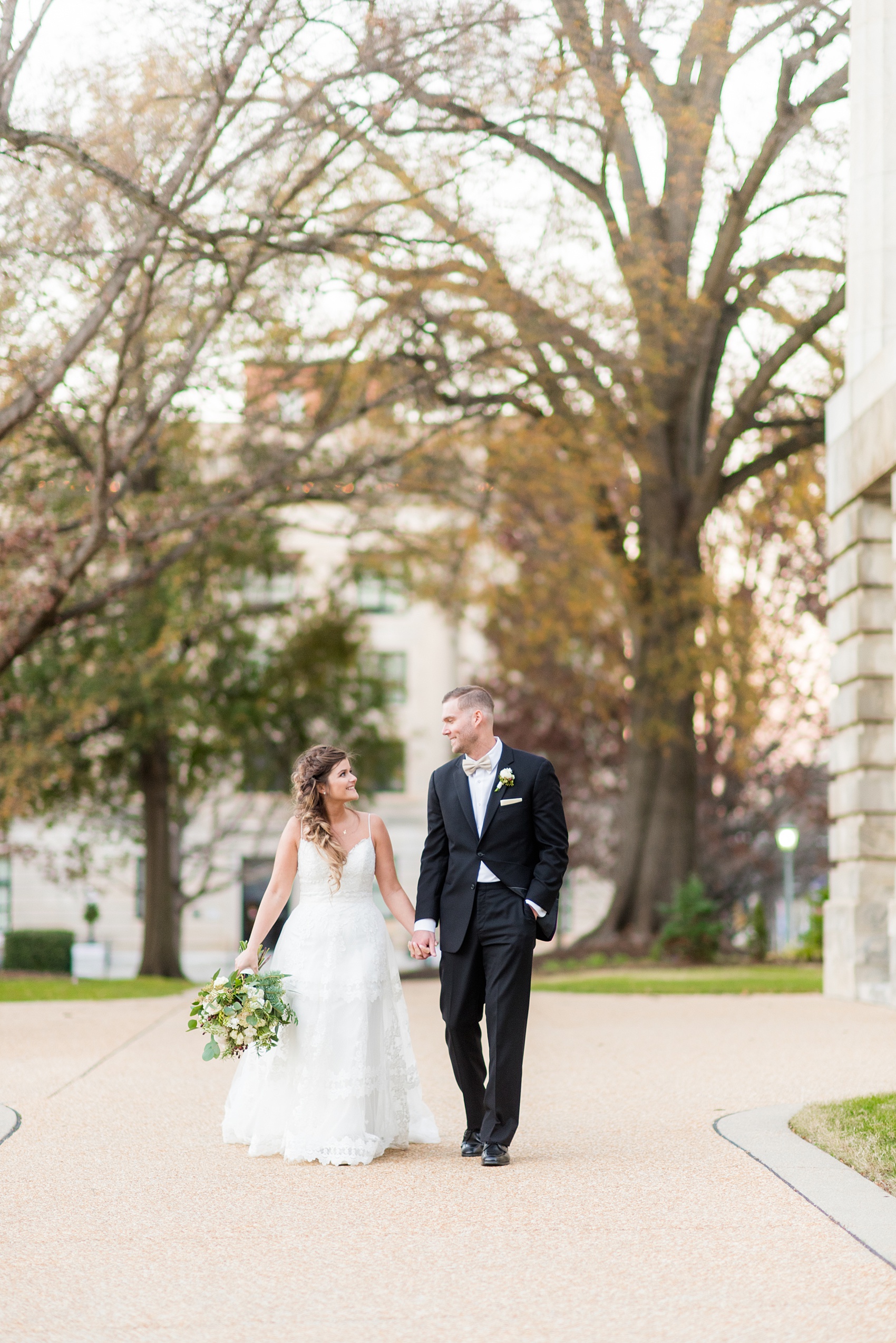 Pictures from a Christmas inspired wedding in downtown Raleigh, North Carolina by Mikkel Paige Photography. The bride and groom took outdoor portraits by their church. Click through for more ideas from their beautiful celebration, including details and decor photos in a green and gold decor palette for their reception. #mikkelpaige #raleighweddingphotographer #downtownRaleigh #christmaswedding #greenandgoldwedding #brideandgroom #bridal