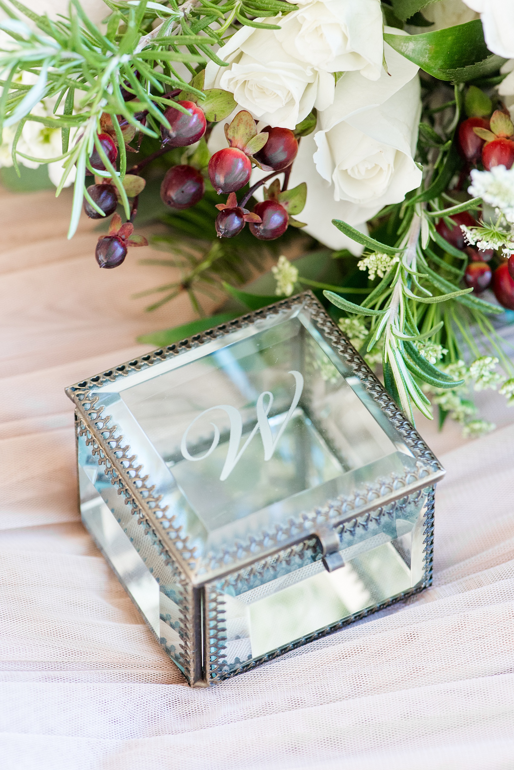 Pictures from a Christmas inspired wedding in downtown Raleigh, North Carolina by Mikkel Paige Photography. The bride got ready for their wedding at The Glass Box while their photographer captured their detail images like this monogrammed glass jewelry box. Click through for more ideas from their beautiful celebration, including decor photos in a green and gold decor palette for their reception. #mikkelpaige #raleighweddingphotographer #downtownRaleigh #greenandgoldwedding #detailphotos