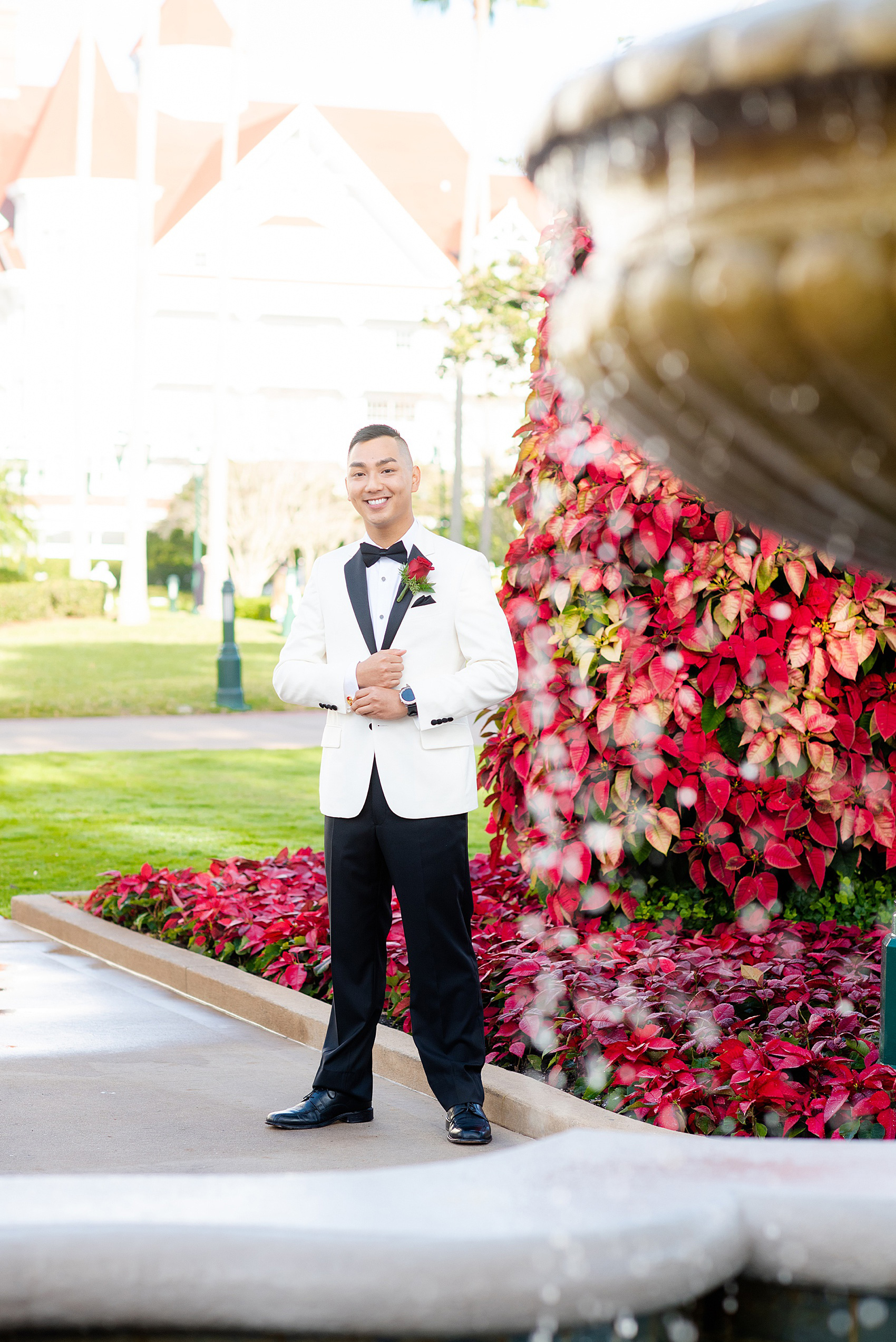 Photographs of a Walt Disney World groom by Mikkel Paige Photography. As a lover of Marvel comics, he wove a small detail from Iron Man into his white tuxedo with gold and red cufflinks. He got ready for his day at the dream resort, the Grand Floridian, with his groomsmen and wore a red rose boutonniere for his bride’s love of a Beauty and the Beast theme. #disneywedding #disneybride #waltdisneyworld #DisneyWorldWedding