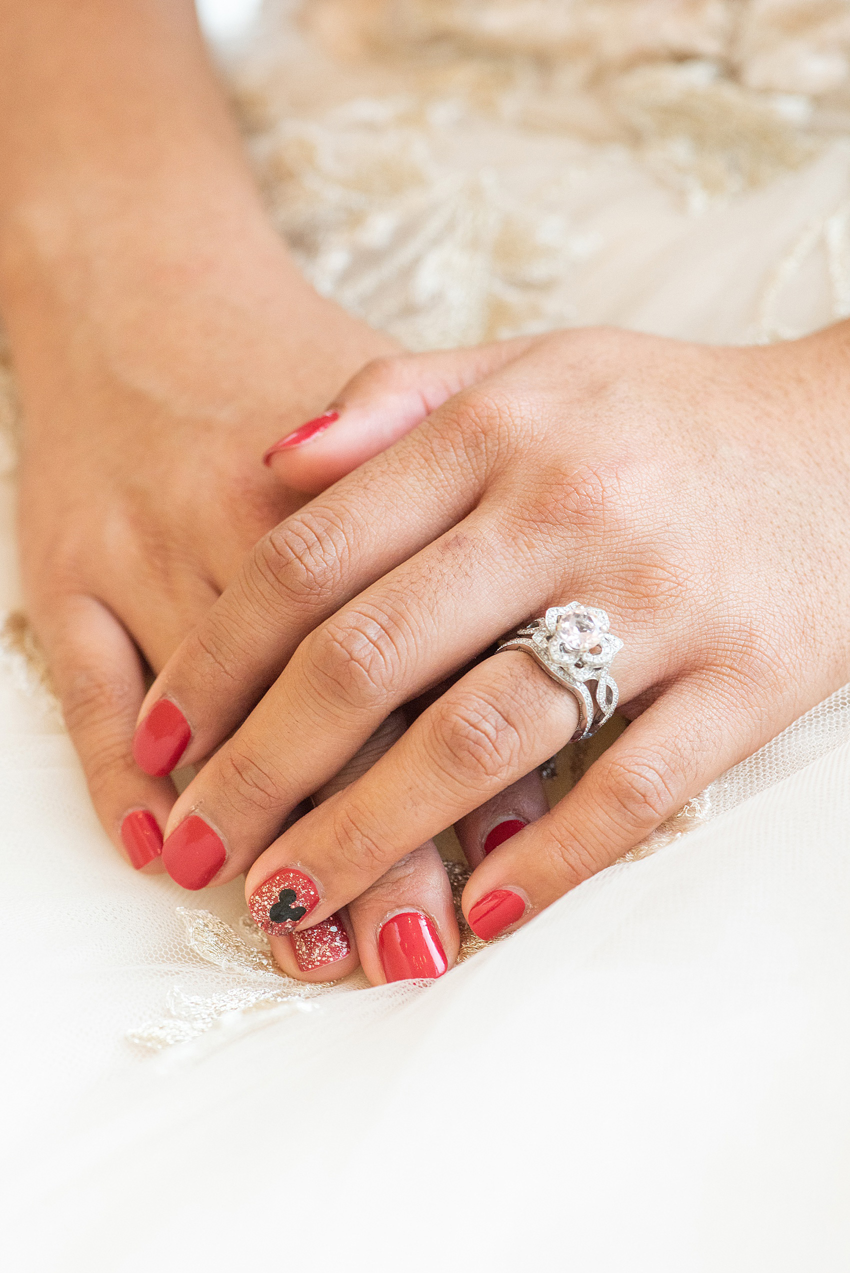 Photographs of a Walt Disney World bride by Mikkel Paige Photography. As a lover of Beauty and the Beast and Mickey Mouse, the bride wove details from the classic Disney film into her wedding. Her beautiful rose embroidered dress was befitting of a princess. She got ready for her day at the dream resort, the Grand Floridian. Her hair was twisted into a fun, rose bun and she had a Mickey Mouse nail on her glitter manicure. #disneywedding #disneybride #DisneyWorldWedding #MickeyManicure