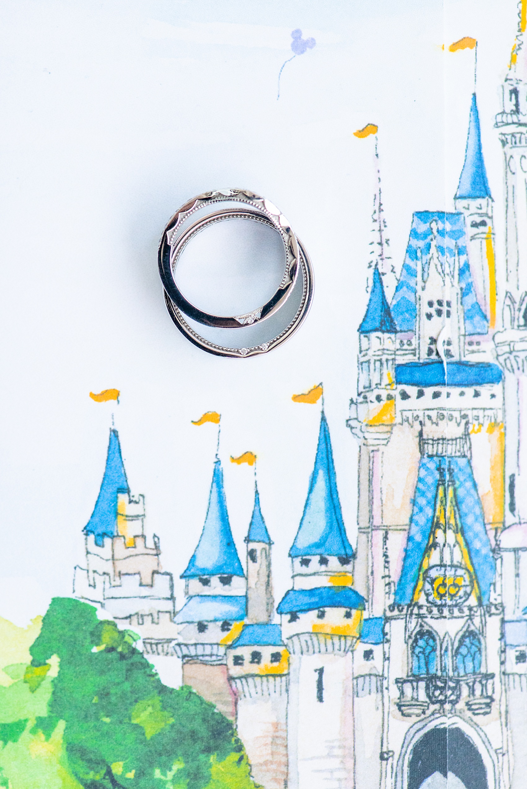 Photographs of a Walt Disney World wedding by Mikkel Paige Photography. The bride’s engagement ring was themed to Beauty and the Beast with a pink morganite center stone. It perfectly matched their invitations with Cinderella Castle as the main watercolor and the movie glass rose dome on the RSVP card. #disneywedding #disneybride #waltdisneyworld #DisneyWorldWedding #morganitering #pinkengagementring #rosering #BeautyandtheBeast