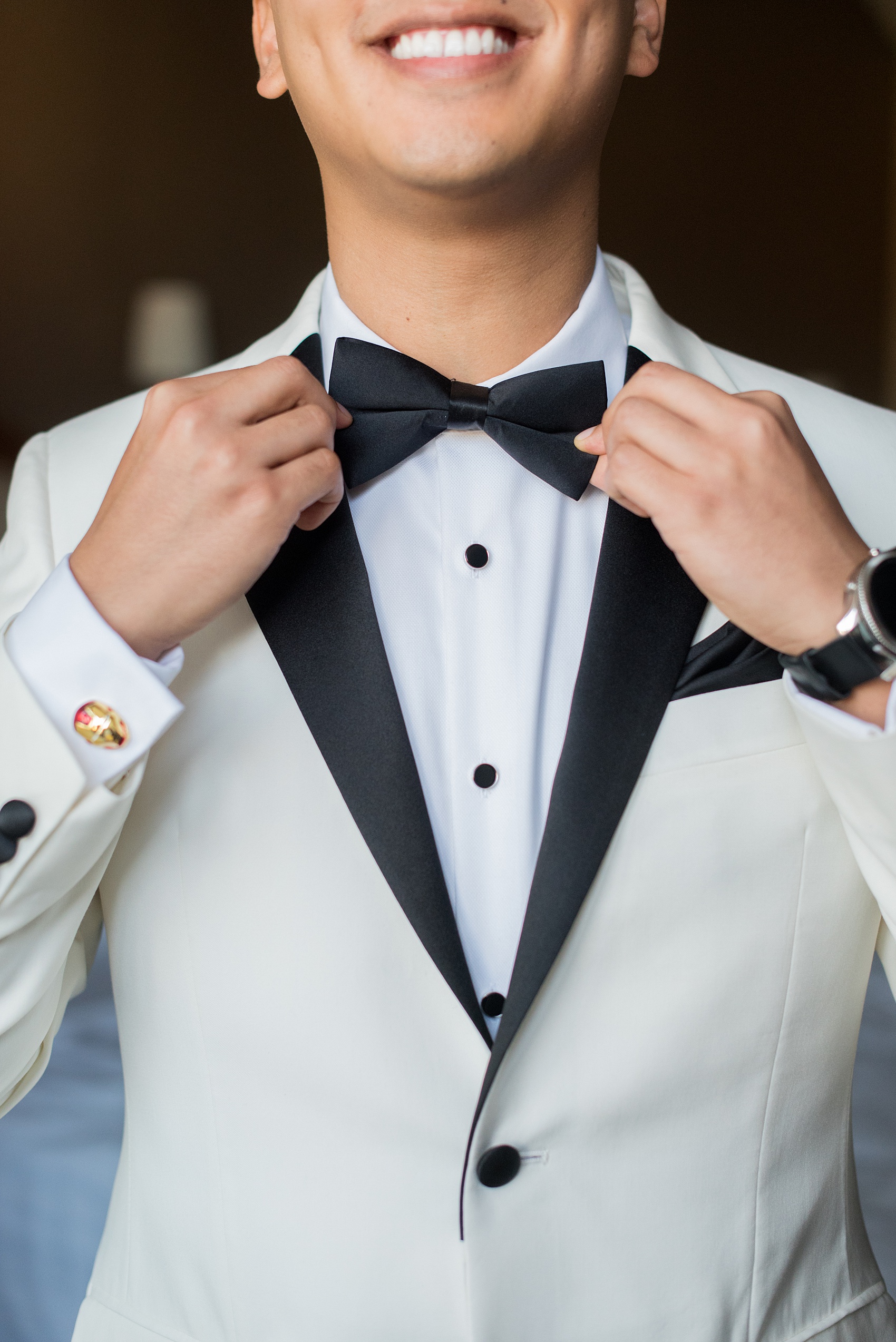 Photographs of a Walt Disney World groom by Mikkel Paige Photography. As a lover of Marvel comics, he wove a small detail from Iron Man into his white tuxedo with gold and red cufflinks. He got ready for his day at the dream resort, the Grand Floridian, with his groomsmen and wore a red rose boutonniere for his bride’s love of a Beauty and the Beast theme. #disneywedding #disneybride #waltdisneyworld #DisneyWorldWedding