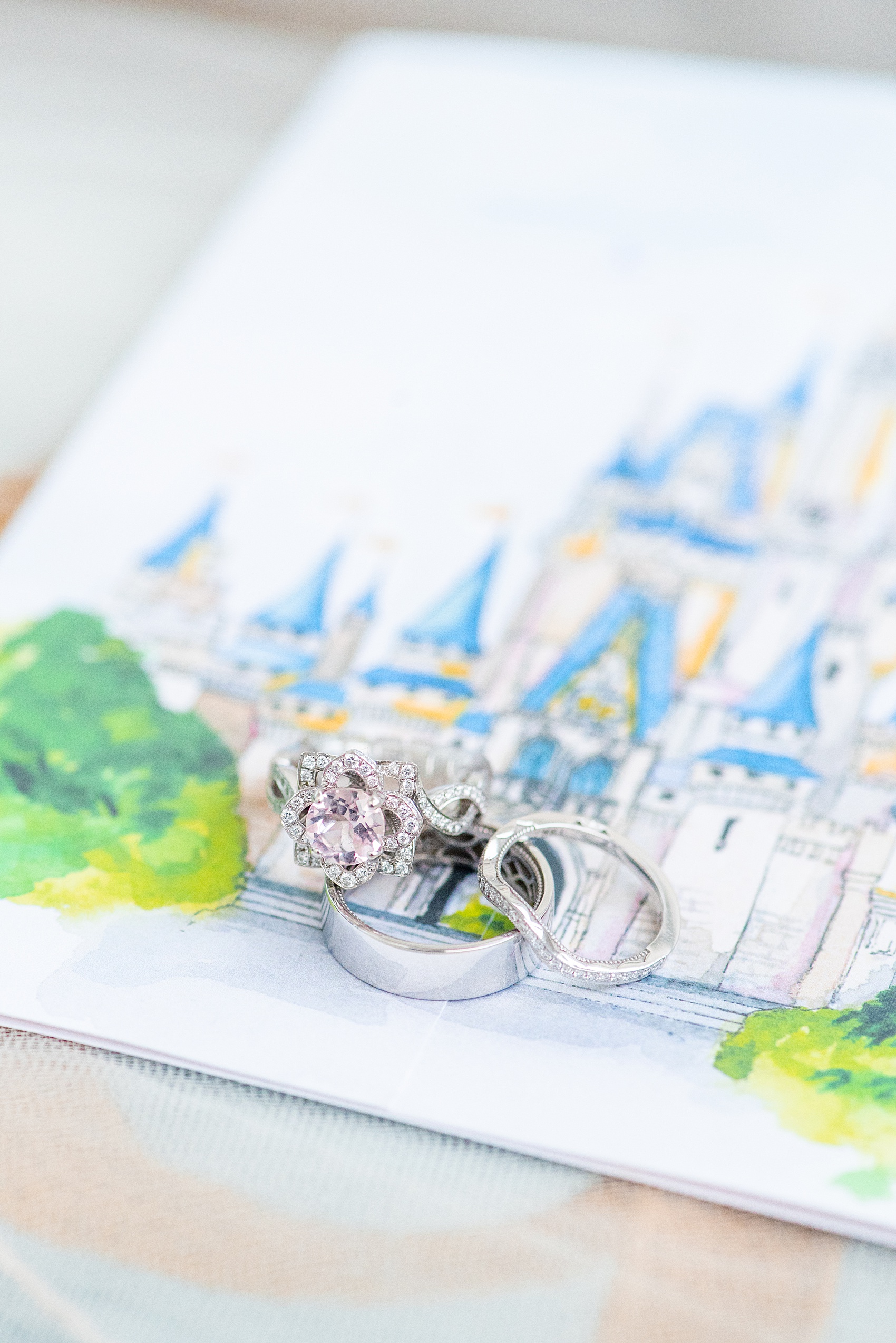 Photographs of a Walt Disney World wedding by Mikkel Paige Photography. The bride’s engagement ring was themed to Beauty and the Beast with a pink morganite center stone. It perfectly matched their invitations with Cinderella Castle as the main watercolor and the movie glass rose dome on the RSVP card. #disneywedding #disneybride #waltdisneyworld #DisneyWorldWedding #morganitering #pinkengagementring #rosering #BeautyandtheBeast