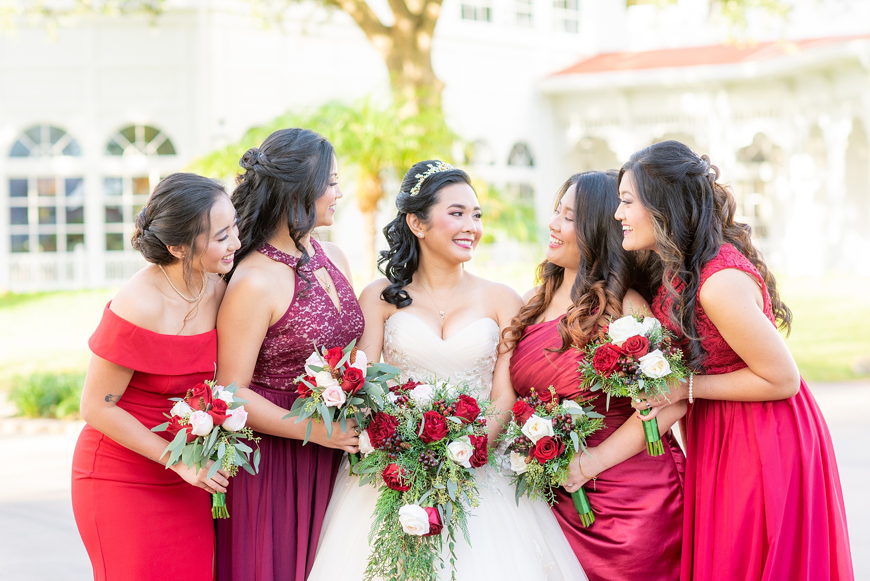 Photographs of a Walt Disney World bridal party by Mikkel Paige Photography. The bride chose the venues of the Grand Floridian, Wedding Pavilion and The Contemporary Resort for photos and fun locations. One even overlooked the Magic Kingdom Park! Their dream wedding included red details: the bridesmaids wore mismatched dresses and carried rose bouquets. #disneywedding #disneybride #waltdisneyworld #DisneyWorldWedding #BeautyandtheBeast #redrosewedding