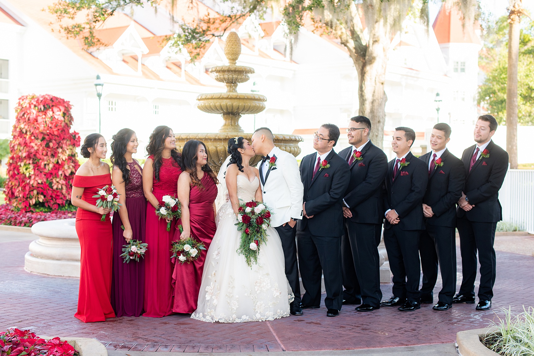 Photographs of a Walt Disney World bridal party by Mikkel Paige Photography. The bride chose the venues of the Grand Floridian, Wedding Pavilion and The Contemporary Resort for photos and fun locations. One even overlooked the Magic Kingdom Park! Their dream wedding included red details: the bridesmaids wore mismatched dresses and carried rose bouquets. #disneywedding #disneybride #waltdisneyworld #DisneyWorldWedding #BeautyandtheBeast #redrosewedding