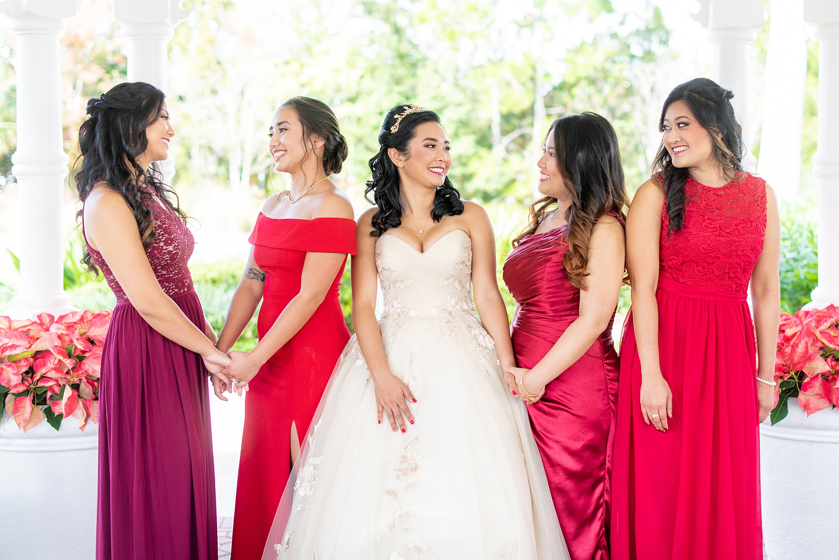 Photographs of a Walt Disney World bridal party by Mikkel Paige Photography. The bride chose the venues of the Grand Floridian, Wedding Pavilion and The Contemporary Resort for photos and fun locations. One even overlooked the Magic Kingdom Park! Their dream wedding included red details: the bridesmaids wore mismatched dresses and carried rose bouquets. #disneywedding #disneybride #waltdisneyworld #DisneyWorldWedding #BeautyandtheBeast #redrosewedding