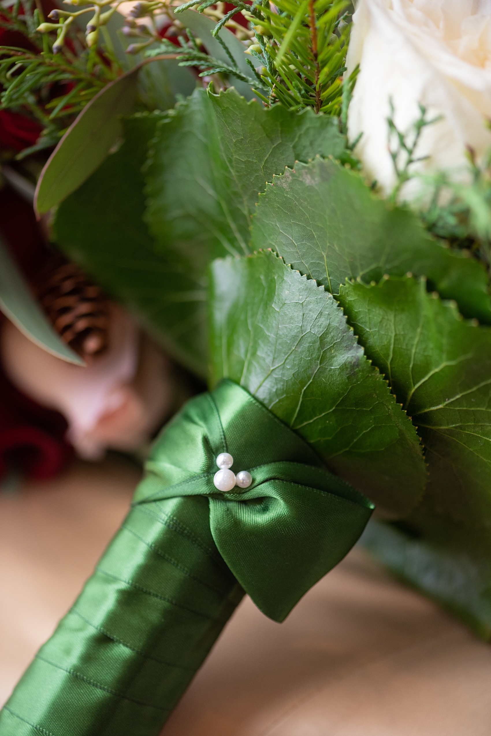 Walt Disney World photographs by Mikkel Paige Photography. The bride had a December themed wedding at the Grand Floridian Resort, Wedding Pavilion and Contemporary Hotel. It had a Beauty and the Beast theme and she wore a beautiful embroidered dress, befitting of a princess. Her pink and red rose bouquet had holiday greenery, a pearl hidden Mickey and small pine cones in it with a cascading effect. #disneywedding #disneybride #waltdisneyworld #DisneyWorldWedding #hiddenmickey