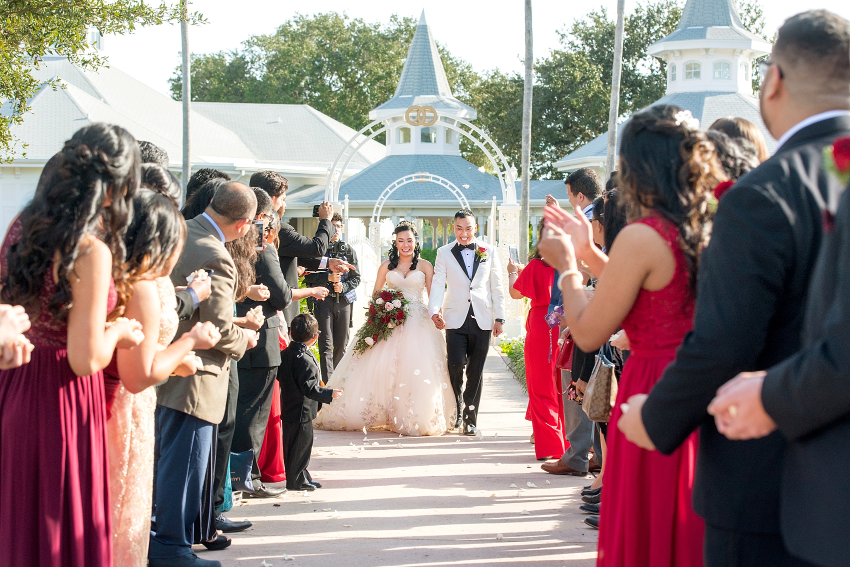 Photographs of a Walt Disney World wedding by Mikkel Paige Photography will give you ideas for a tasteful Beauty and the Beast theme. There was a glass dome with a red rose inside at the start of the ceremony with red rose petals scattered down the aisle for a small, intimate guest list at the Wedding Pavilion next to the Grand Floridian resort. #disneywedding #disneybride #waltdisneyworld #DisneyWorldWedding #DisneyCeremony #DisneyWorldWeddingPavilion