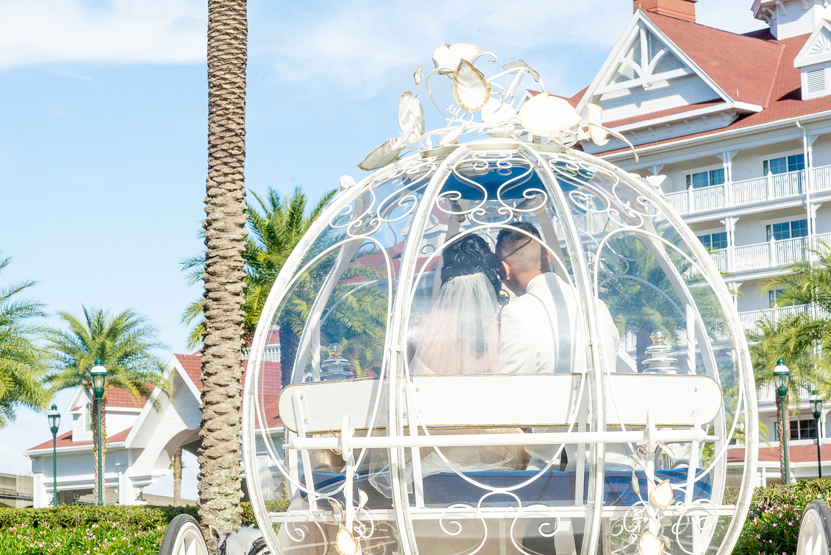 Walt Disney World photographs by Mikkel Paige Photography. The bride and groom celebrated to their ceremony in style in Cinderella’s Glass Coach with white ponies. They took pictures at the Grand Floridian Resort and Wedding Pavilion with this awesome transportation. #disneywedding #disneybride #waltdisneyworld #DisneyWorldWedding #CinderellaCarriage #GlassCoach