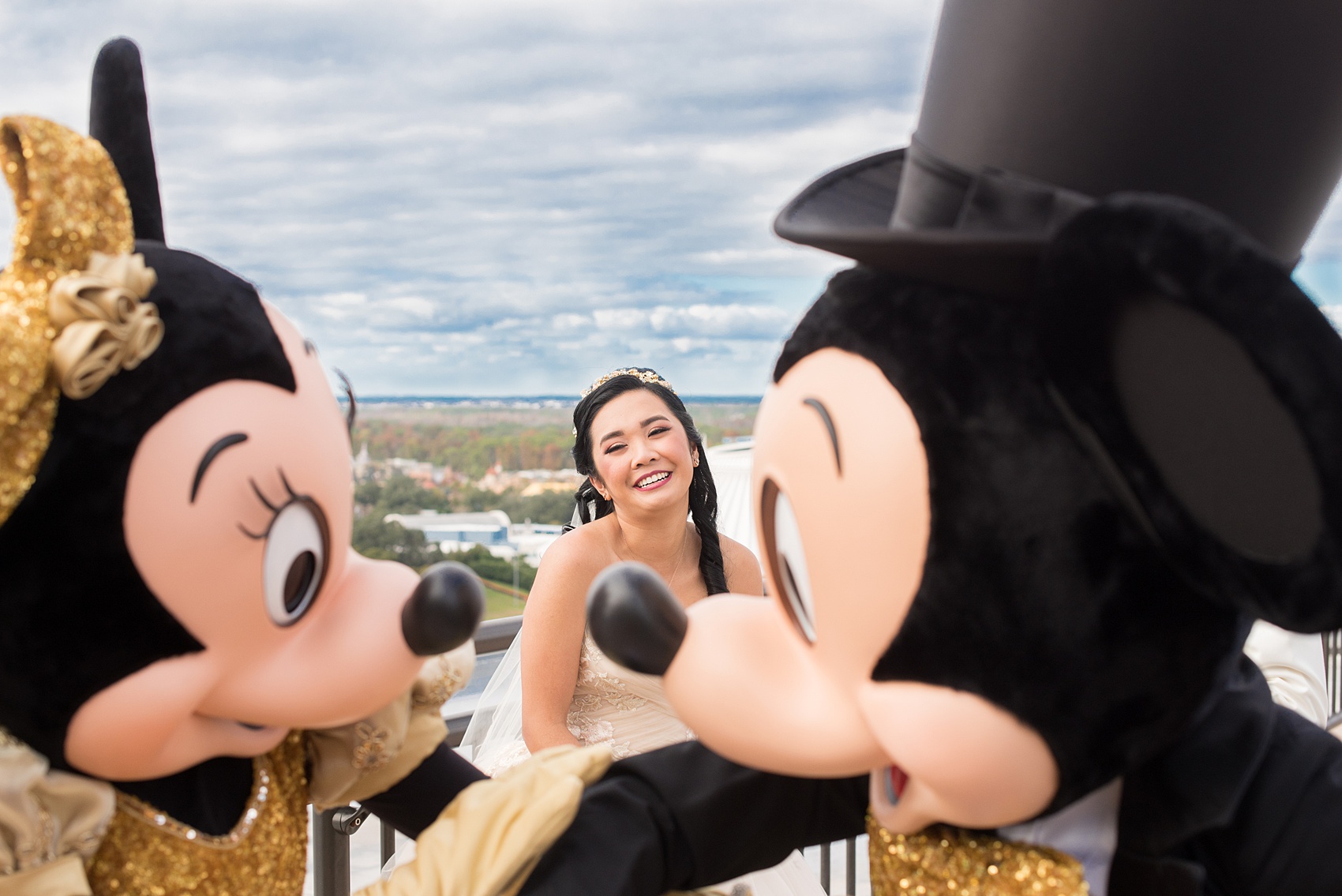 Photographs of a Walt Disney World wedding by Mikkel Paige Photography. The bride and groom had cake cutting help from Mickey Mouse and Minnie Mouse in formal attire! Their reception venue at The Contemporary Resort’s California Grill was great for fun, awesome photos with them. It overlooked the Magic Kingdom Park and Cinderella Castle! Their small, dream day included red rose details and a Beauty and the Beast theme. #disneywedding #DisneyWorldWedding #BeautyandtheBeast #MickeyandMinnie