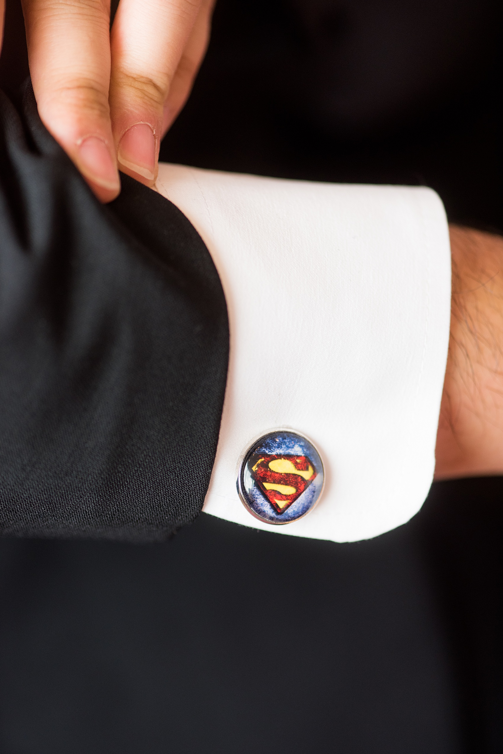 Photographs of a Walt Disney World bridal party by Mikkel Paige Photography. The groom wore a white tuxedo to his wedding venues of the Grand Floridian, Wedding Pavilion and The Contemporary Resort. They all wore rose boutonnieres and marvel comic cufflinks, a small detail that was an awesome way to incorporate a fun idea. #disneywedding #disneybride #waltdisneyworld #DisneyWorldWedding #BeautyandtheBeast #redrosewedding #superman