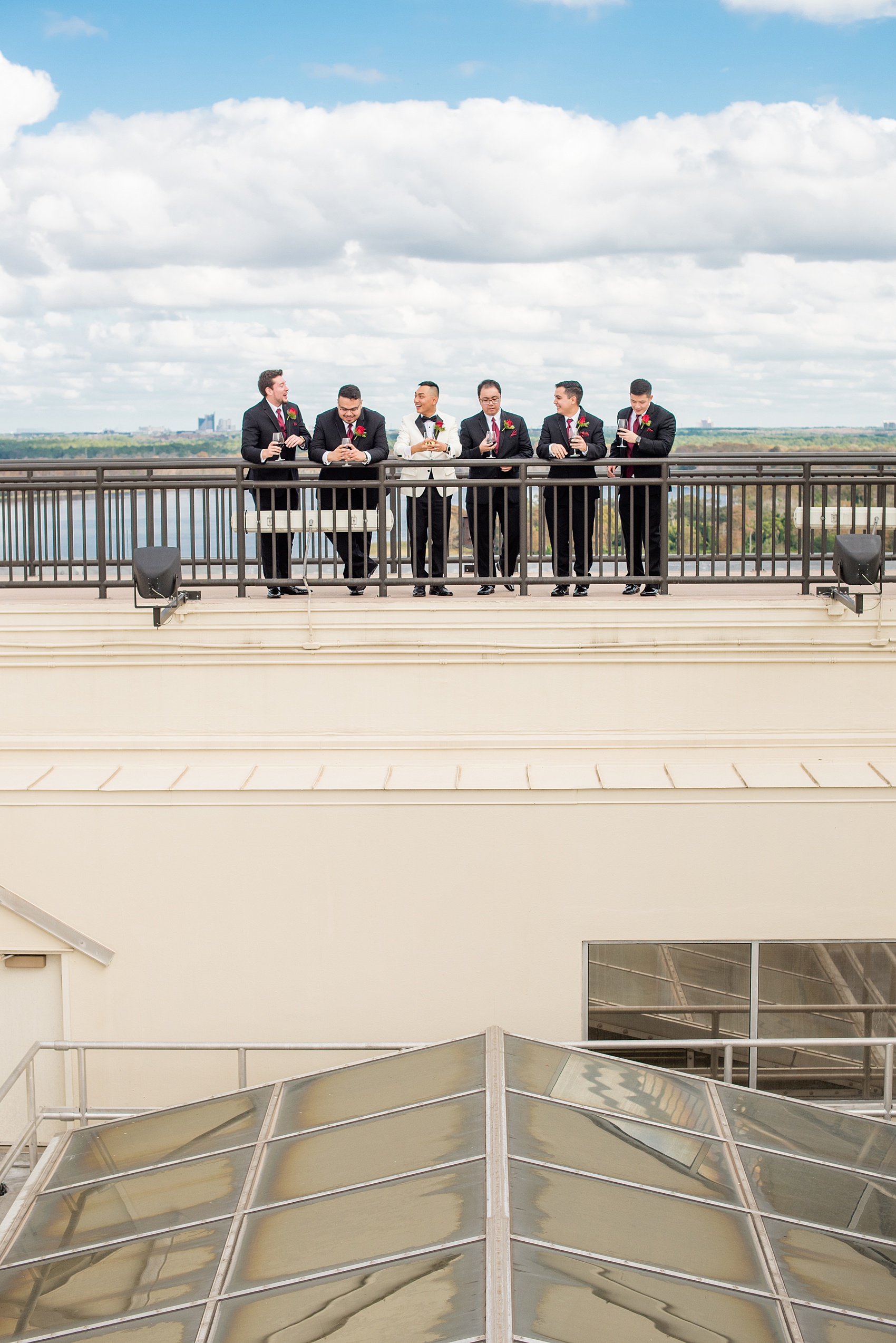 Photographs of a Walt Disney World bridal party by Mikkel Paige Photography. The groom wore a white tuxedo to his wedding venues of the Grand Floridian, Wedding Pavilion and The Contemporary Resort. They all wore rose boutonnieres and marvel comic cufflinks, a small detail that was an awesome way to incorporate a fun idea. #disneywedding #disneybride #waltdisneyworld #DisneyWorldWedding #BeautyandtheBeast #redrosewedding