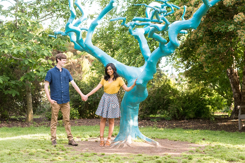 Raleigh engagement photos with murals and spring flowers in the downtown area by Mikkel Paige Photography. The bride and groom choose JC Raulston Arboretum and the Marbles Kids Museum mural for their pictures. #DowntownRaleigh #RaleighWeddingPhotographer #mikkelpaige #RaleighPhotographer #RaleighPhotos #RaleighNC #NorthCarolinaPhotographer