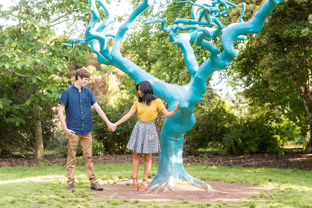 Raleigh engagement photos with murals and spring flowers in the downtown area by Mikkel Paige Photography. The bride and groom choose JC Raulston Arboretum and the Marbles Kids Museum mural for their pictures. #DowntownRaleigh #RaleighWeddingPhotographer #mikkelpaige #RaleighPhotographer #RaleighPhotos #RaleighNC #NorthCarolinaPhotographer