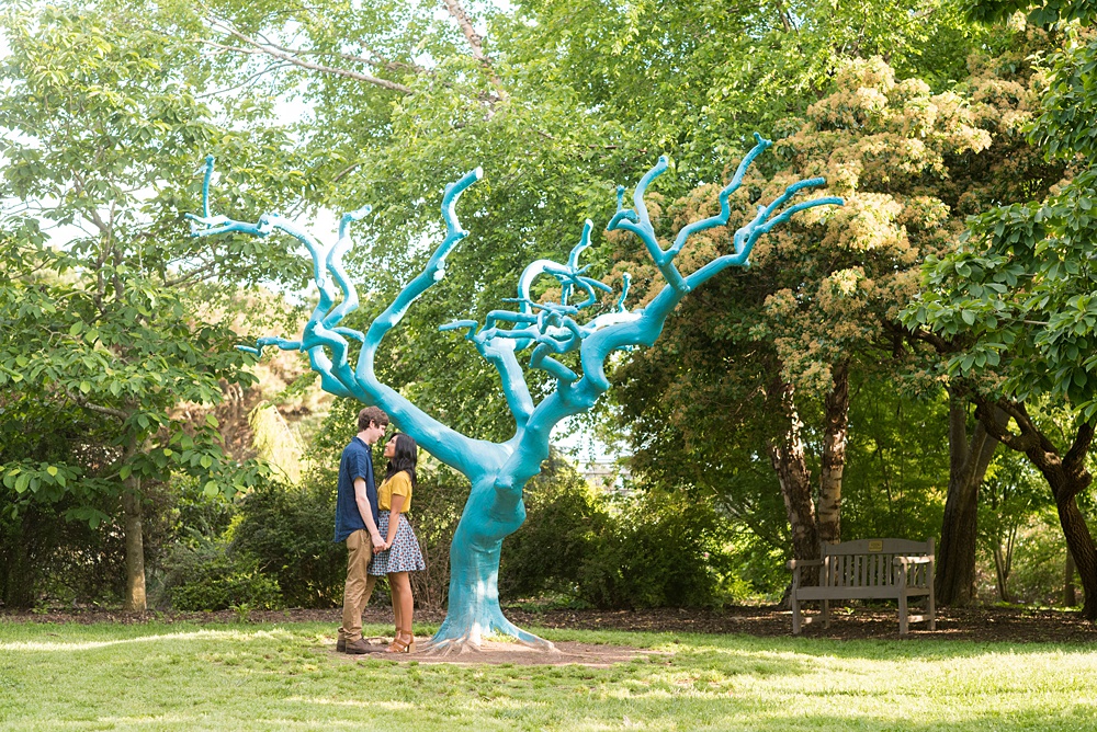 Raleigh engagement photos with murals and spring flowers in the downtown area by Mikkel Paige Photography. The bride and groom choose JC Raulston Arboretum and the Marbles Kids Museum mural for their pictures. #DowntownRaleigh #RaleighWeddingPhotographer #mikkelpaige #RaleighPhotographer #RaleighPhotos #RaleighNC #NorthCarolinaPhotographer