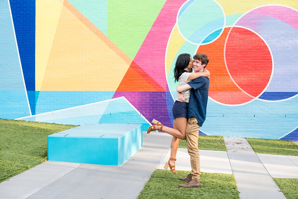 Raleigh engagement photos with murals and spring flowers in the downtown area by Mikkel Paige Photography. The bride and groom choose JC Raulston Arboretum and the Marbles Kids Museum mural for their pictures. #DowntownRaleigh #RaleighWeddingPhotographer #mikkelpaige #RaleighPhotographer #RaleighPhotos #RaleighNC #NorthCarolinaPhotographer