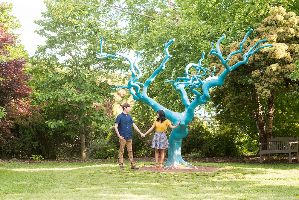 Raleigh engagement photos with murals and spring flowers in the downtown area by Mikkel Paige Photography. The bride and groom choose JC Raulston Arboretum and the Marbles Kids Museum mural for their pictures. #DowntownRaleigh #RaleighWeddingPhotographer #mikkelpaige #RaleighPhotographer #RaleighPhotos #RaleighNC #NorthCarolinaPhotographer