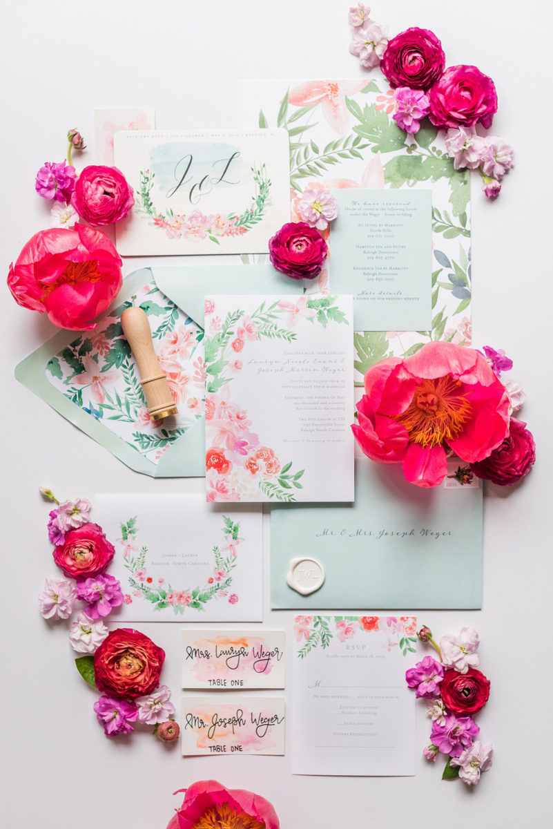 Floral watercolor wedding stationery and invitations for a spring wedding in downtown Raleigh, North Carolina, at the event venue The Stockroom at 230 and The Glass Box. Their photographer, Mikkel Paige Photography, captured this lay flat of their hot pink and aqua blue invitation by @OneandOnlyPaper. #MikkelPaige #DowntownRaleigh #RaleighWedding #RaleighVenue #TheStockroomat230 #floralwatercolorinvitation #weddinginvitation #peonyweddinginspiration #oopaper #oneandonlypaper #layflatphotography