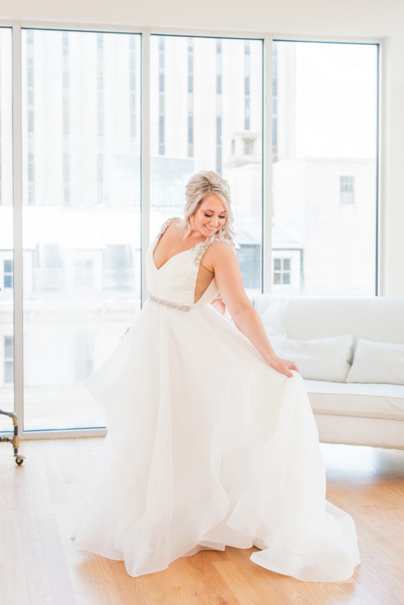 A beautiful spring wedding in Raleigh, North Carolina, at the event venue, The Stockroom at 230 and The Glass Box. Pictures of the bride getting ready with her yorkie dog by their photographer, Mikkel Paige Photography. Their hot pink and aqua colors were perfect for May as the bridesmaids celebrated with a champagne toast in floral robes. #MikkelPaige #DowntownRaleigh #RaleighWedding #RaleighVenue #TheStockroomat230 #bridesmaidsrobes #weddinggettingready