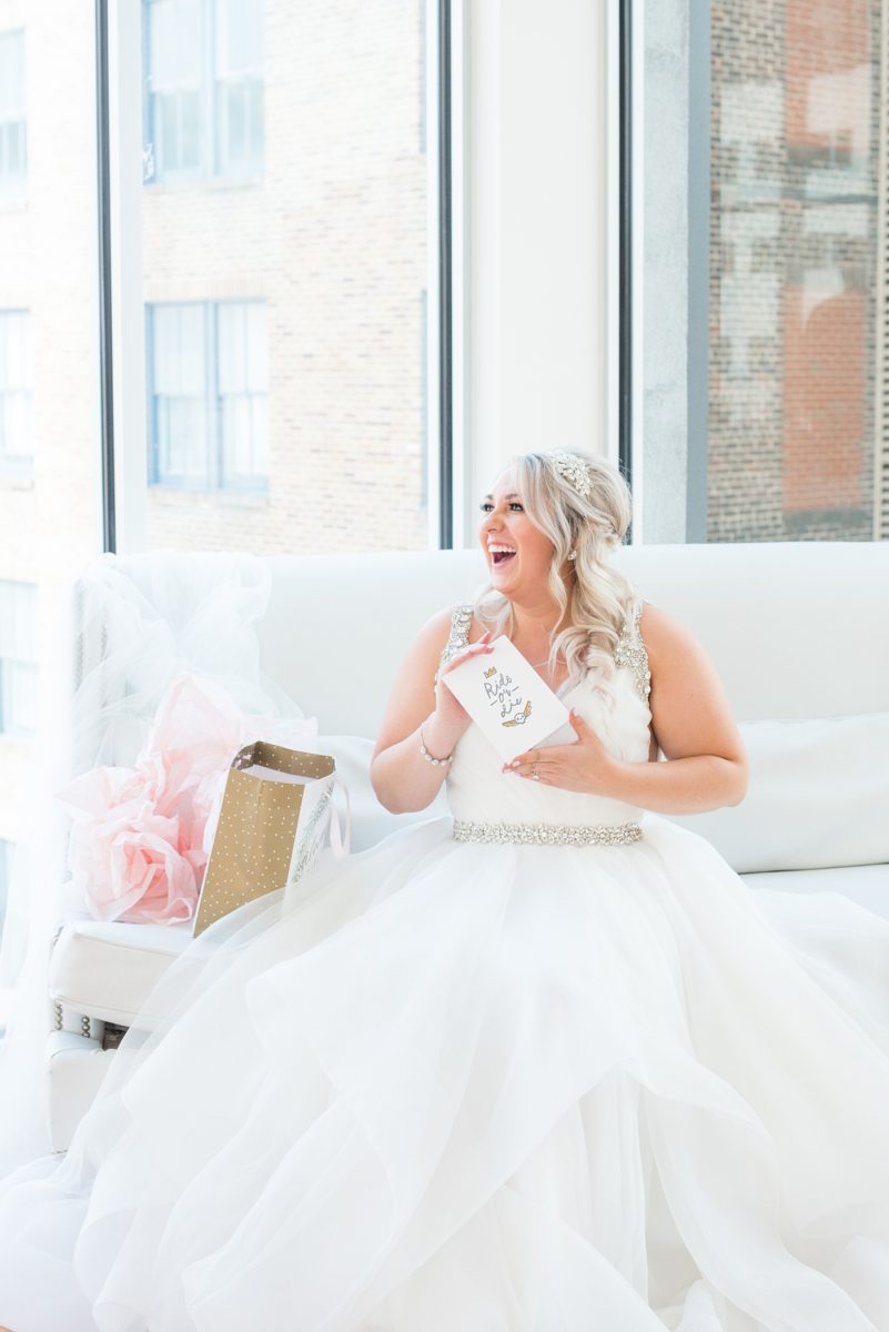 A beautiful spring wedding in Raleigh, North Carolina, at the event venue, The Stockroom at 230 and The Glass Box. Pictures of the bride getting ready with her yorkie dog by their photographer, Mikkel Paige Photography. Their hot pink and aqua colors were perfect for May as the bridesmaids celebrated with a champagne toast in floral robes. #MikkelPaige #DowntownRaleigh #RaleighWedding #RaleighVenue #TheStockroomat230 #bridesmaidsrobes #weddinggettingready