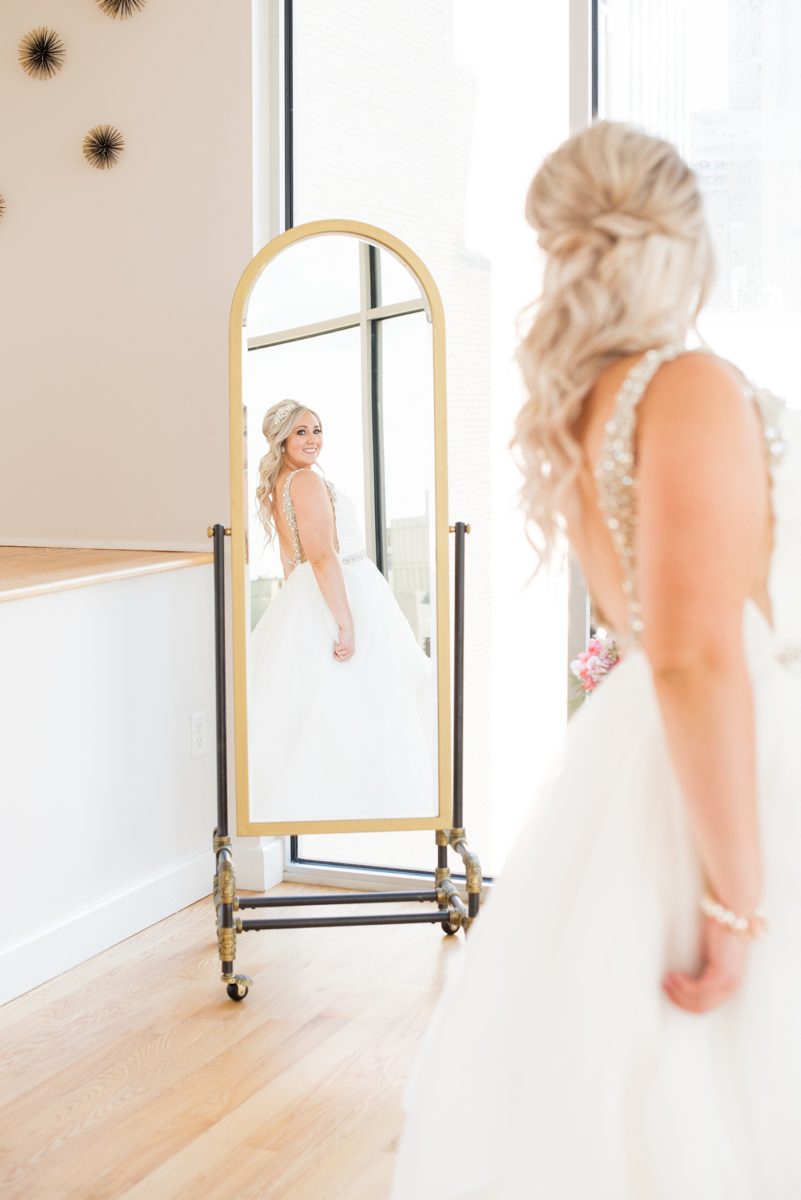 A beautiful spring wedding in Raleigh, North Carolina, at the event venue, The Stockroom at 230 and The Glass Box. Pictures of the bride getting ready with her yorkie dog by their photographer, Mikkel Paige Photography. Their hot pink and aqua colors were perfect for May as the bridesmaids celebrated with a champagne toast in floral robes. #MikkelPaige #DowntownRaleigh #RaleighWedding #RaleighVenue #TheStockroomat230 #bridesmaidsrobes #weddinggettingready