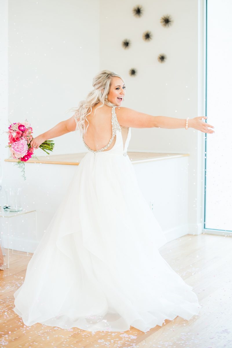 Bridesmaids celebrate with a confetti toss at The Glass Box in downtown Raleigh, North Carolina. The event venue, The Stockroom at 230 was the perfect place for a North Carolina bride and groom to get married. #MikkelPaige #DowntownRaleigh #RaleighWedding #RaleighVenue #TheStockroomat230 #theglassbox #confettiweddingphotos #confetti #weddingparty #bridesmaids #hotpinkbouquet #peonybouquet