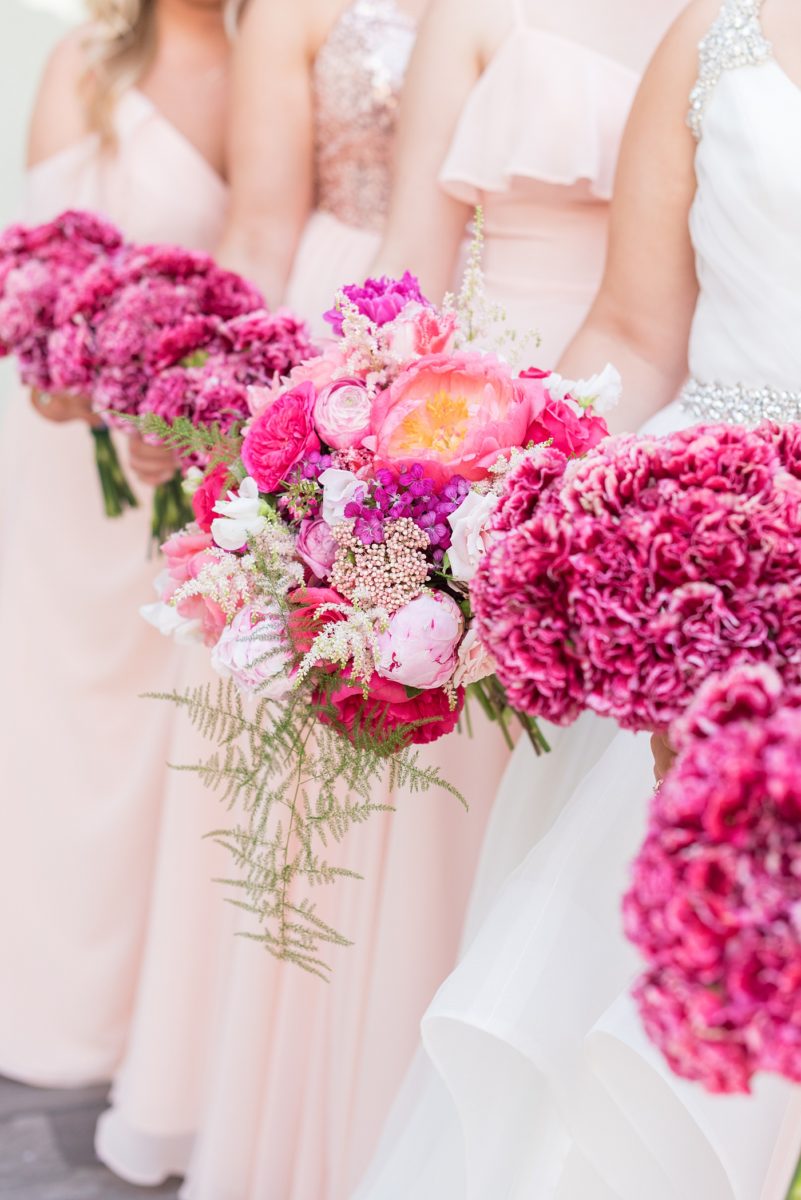 Raleigh wedding photographer, Mikkel Paige Photography, pictures of mismatched pink bridesmaids in downtown Raleigh, North Carolina at the event venue The Stockroom at 230, The Glass Box, and capital building. Their hot pink peony + carnation bouquets were perfect for a spring May celebration. #MikkelPaige #DowntownRaleigh #RaleighWedding #RaleighVenue #TheStockroomat230 #capitalcity #peonies #carnations #pinkbridesmaids #bridalpartyphotos #weddingparty