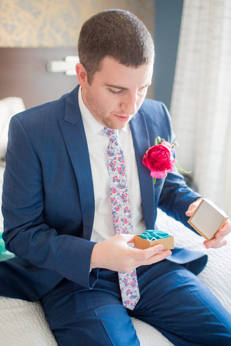 The groom opened a gift from his bride and saw silver custom initial cufflinks for a wedding day gift. Their photographer, Mikkel Paige Photography, captured their spring wedding at the beautiful event venue The Stockroom at 230 in downtown Raleigh, North Carolina. #MikkelPaige #DowntownRaleigh #RaleighWedding #RaleighVenue #TheStockroomat230 #groomgift #customcufflinks #cufflinks #initalcufflinks