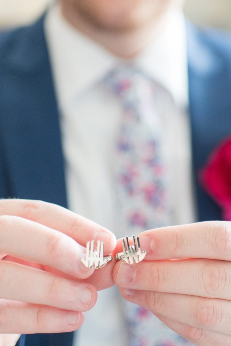 The groom opened a gift from his bride and saw silver custom initial cufflinks for a wedding day gift. Their photographer, Mikkel Paige Photography, captured their spring wedding at the beautiful event venue The Stockroom at 230 in downtown Raleigh, North Carolina. #MikkelPaige #DowntownRaleigh #RaleighWedding #RaleighVenue #TheStockroomat230 #groomgift #customcufflinks #cufflinks #initalcufflinks