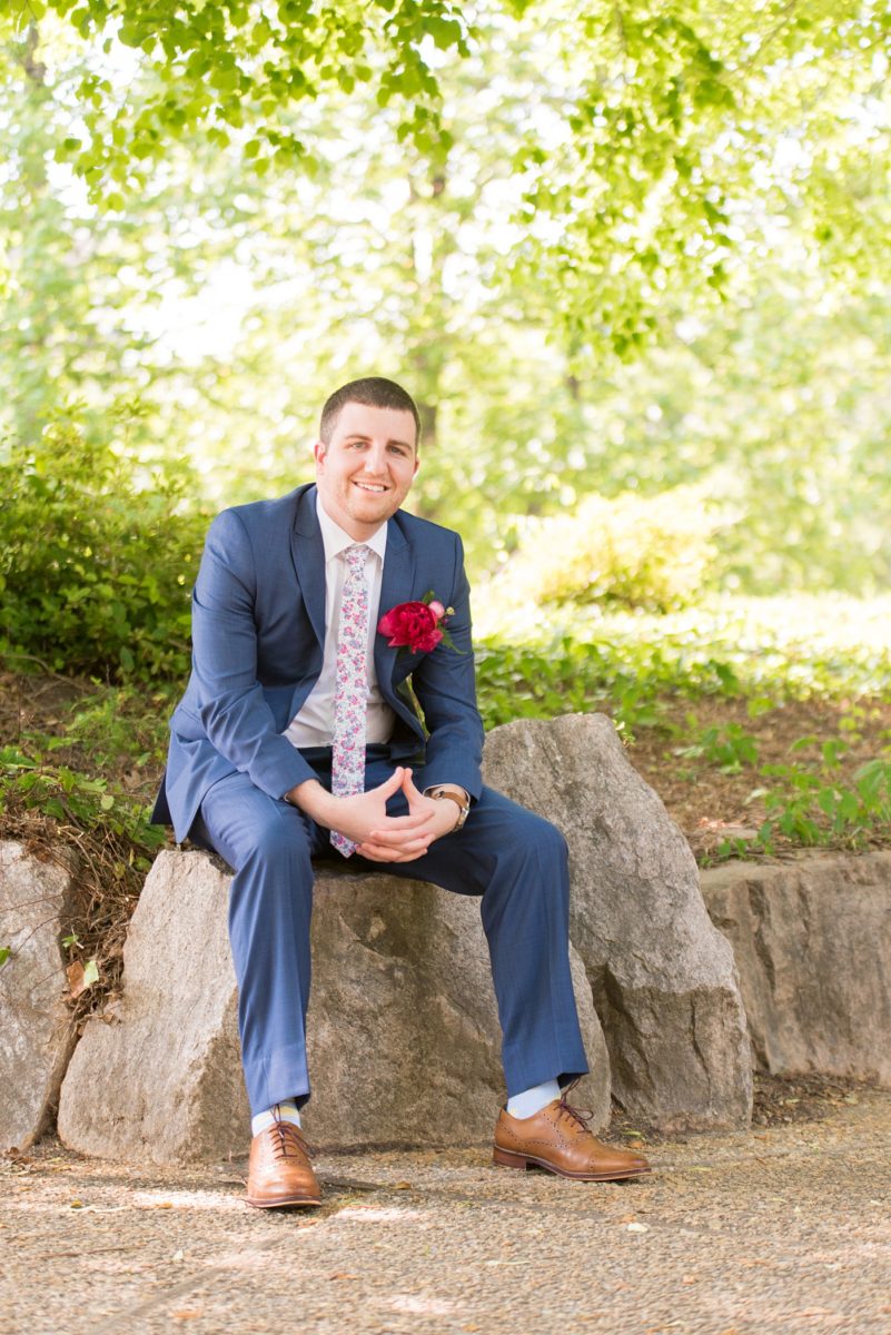 Raleigh wedding photographer, Mikkel Paige Photography, pictures of the groom and his groomsmen in blue suits with floral ties in downtown Raleigh, North Carolina at the event venue The Stockroom at 230 and capital building. The bright colors and hot pink boutonnieres were perfect for a spring May celebration. #MikkelPaige #DowntownRaleigh #RaleighWedding #RaleighVenue #TheStockroomat230 #capitalcity #groomsmen #boutonnieres #bluesuits #floralties #groomstyle