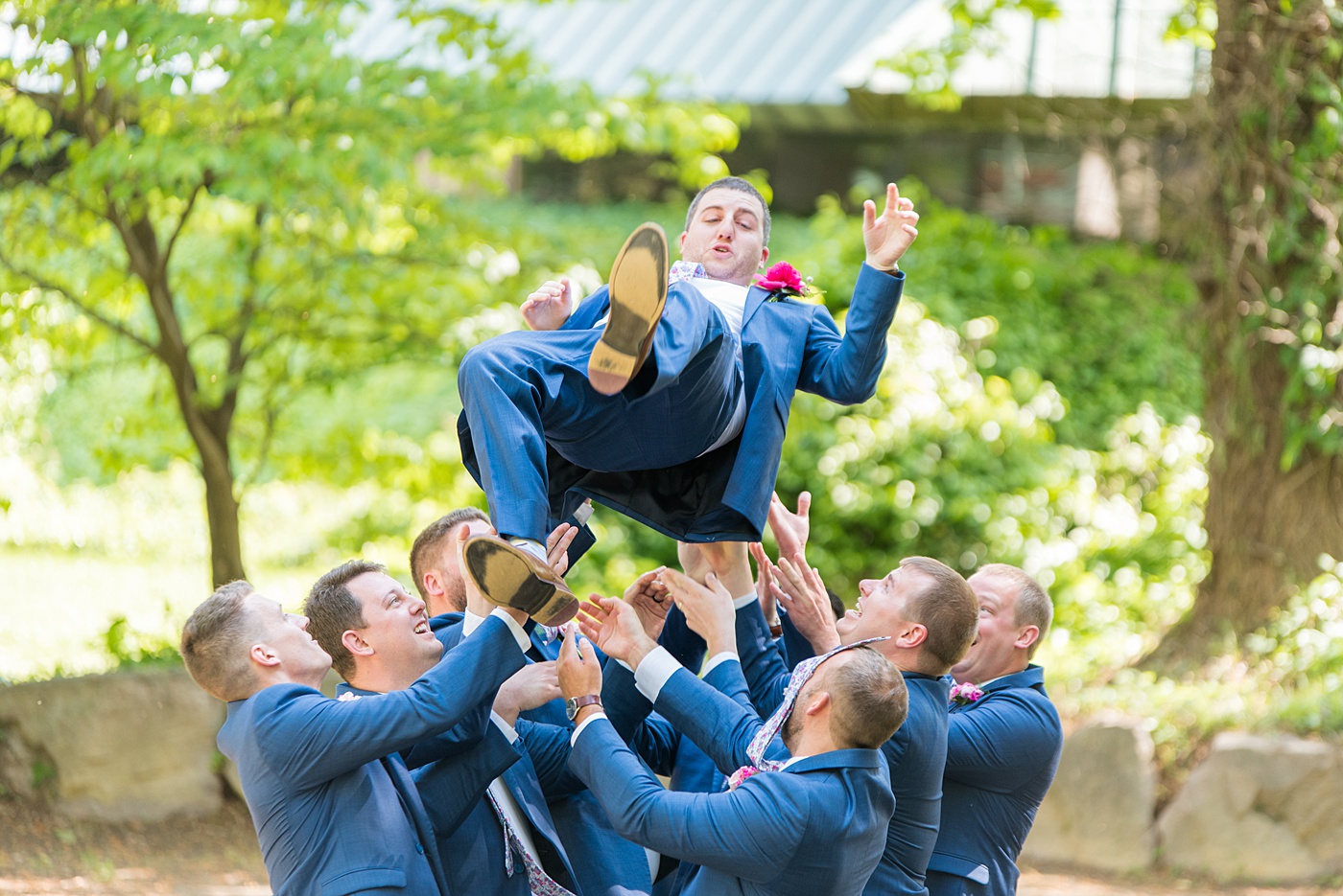 Raleigh wedding photographer, Mikkel Paige Photography, pictures of the groom and his groomsmen in blue suits with floral ties in downtown Raleigh, North Carolina at the event venue The Stockroom at 230 and capital building. The bright colors and hot pink boutonnieres were perfect for a spring May celebration. #MikkelPaige #DowntownRaleigh #RaleighWedding #RaleighVenue #TheStockroomat230 #capitalcity #groomsmen #boutonnieres #bluesuits #floralties #groomstyle #fungroomsmenphotos