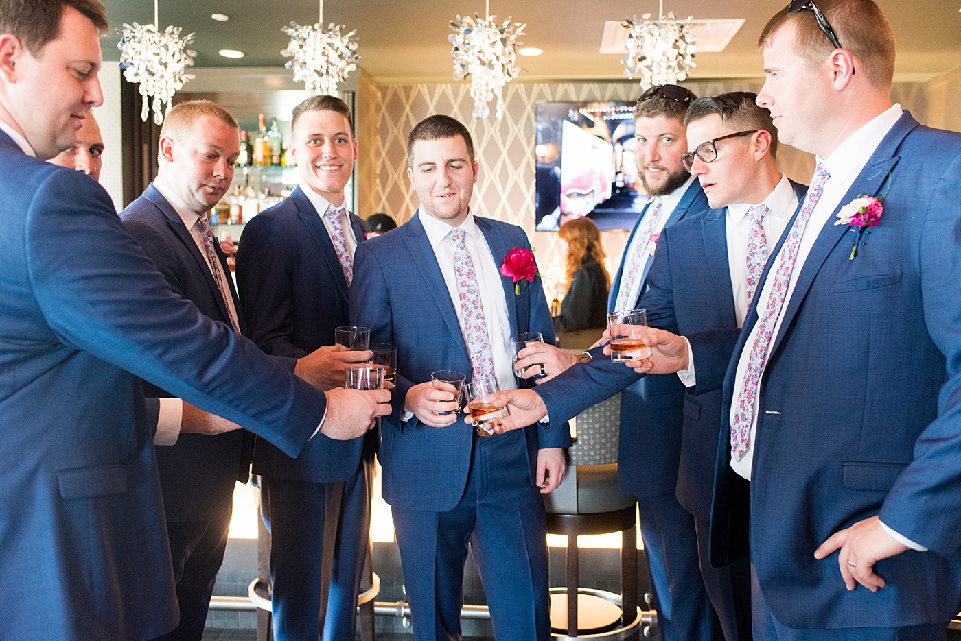 Raleigh wedding photographer, Mikkel Paige Photography, pictures of the groom and his groomsmen in blue suits with floral ties in downtown Raleigh, North Carolina at the event venue The Stockroom at 230 and capital building. The bright colors and hot pink boutonnieres were perfect for a spring May celebration. #MikkelPaige #DowntownRaleigh #RaleighWedding #RaleighVenue #TheStockroomat230 #capitalcity #groomsmen #boutonnieres #bluesuits #floralties #groomstyle