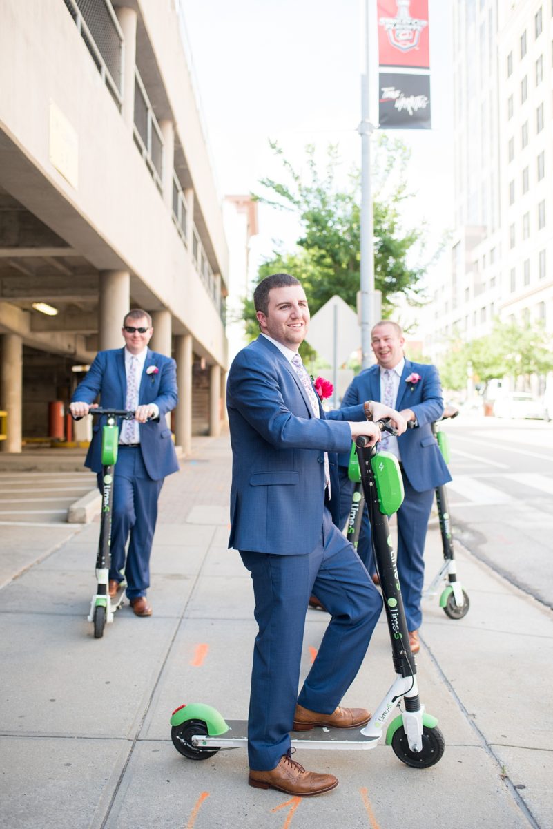 Raleigh wedding photographer, Mikkel Paige Photography, pictures of the groom and his groomsmen in blue suits with floral ties in downtown Raleigh, North Carolina at the event venue The Stockroom at 230 and capital building. The bright colors and hot pink boutonnieres were perfect for a spring May celebration. #MikkelPaige #DowntownRaleigh #RaleighWedding #RaleighVenue #TheStockroomat230 #capitalcity #groomsmen #boutonnieres #bluesuits #floralties #groomstyle