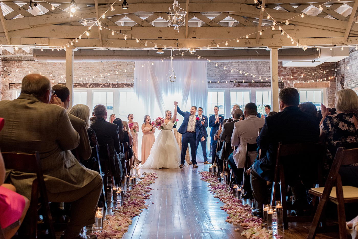 Indoor spring wedding ceremony at the event venue The Stockroom at 230 in Raleigh, North Carolina. Their photographer, Mikkel Paige Photography, captured the bride and groom’s vows in this historic building near the capital downtown. #MikkelPaige #DowntownRaleigh #RaleighWedding #RaleighVenue #TheStockroomat230 #weddingceremony #indoorweddingceremony