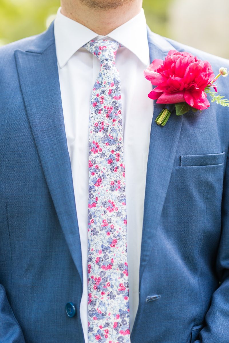 Raleigh wedding photographer, Mikkel Paige Photography, pictures of the groom and his groomsmen in blue suits with floral ties in downtown Raleigh, North Carolina at the event venue The Stockroom at 230 and capital building. The bright colors and hot pink boutonnieres were perfect for a spring May celebration. #MikkelPaige #DowntownRaleigh #RaleighWedding #RaleighVenue #TheStockroomat230 #capitalcity #groomsmen #boutonnieres #bluesuits #floraties #groomstyle #layflatphotography
